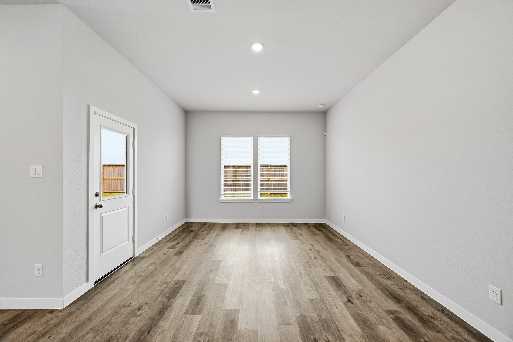 A room with a wood floor and white walls.