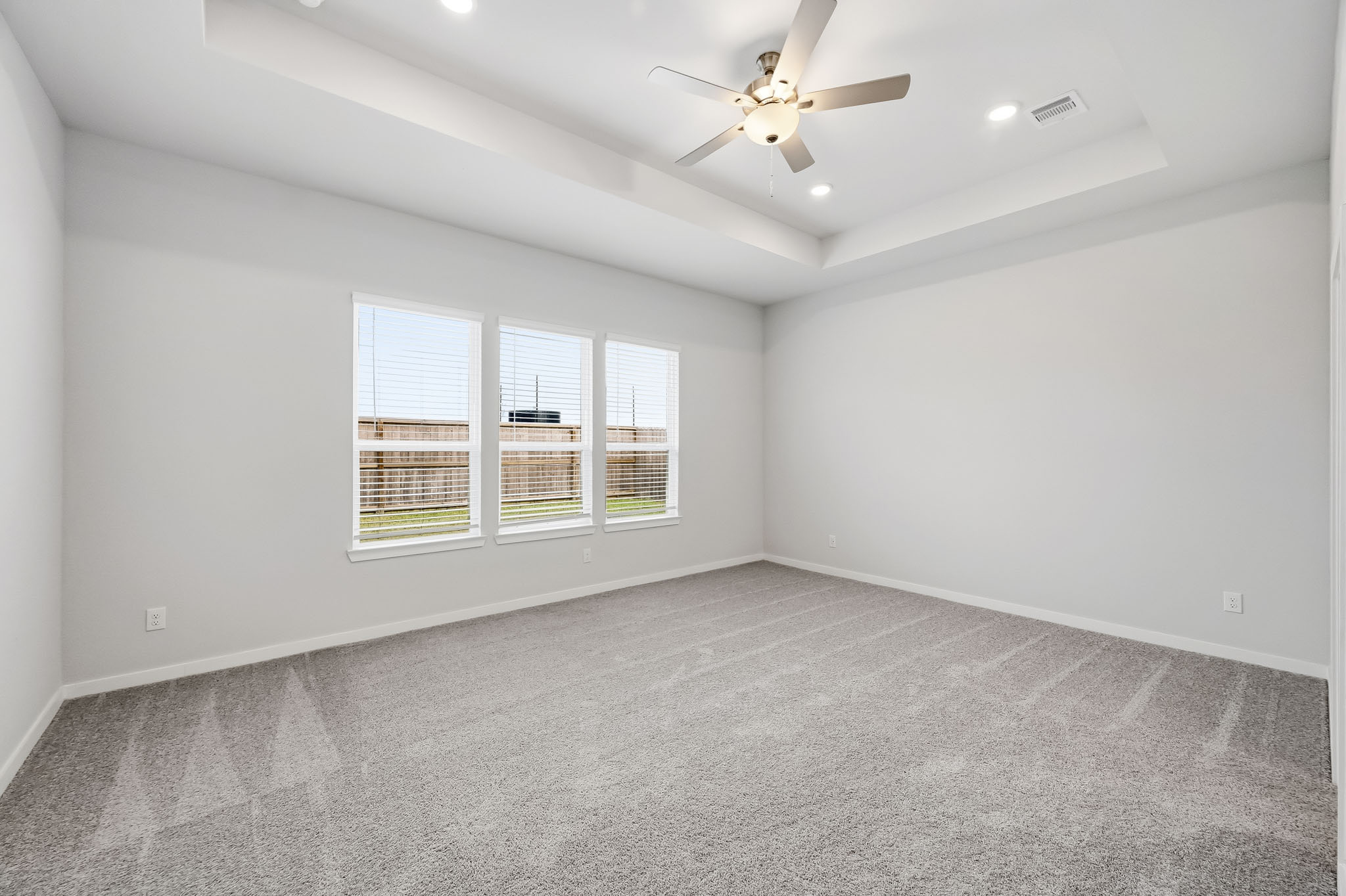 A room with a ceiling fan and a window.