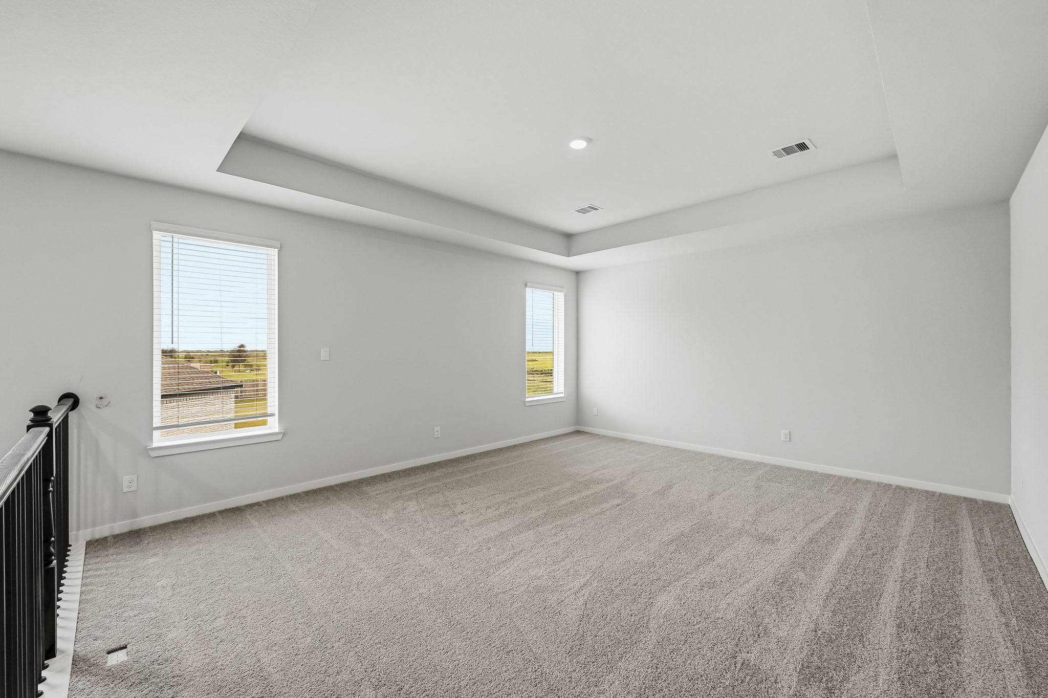 A room with a carpet and windows.