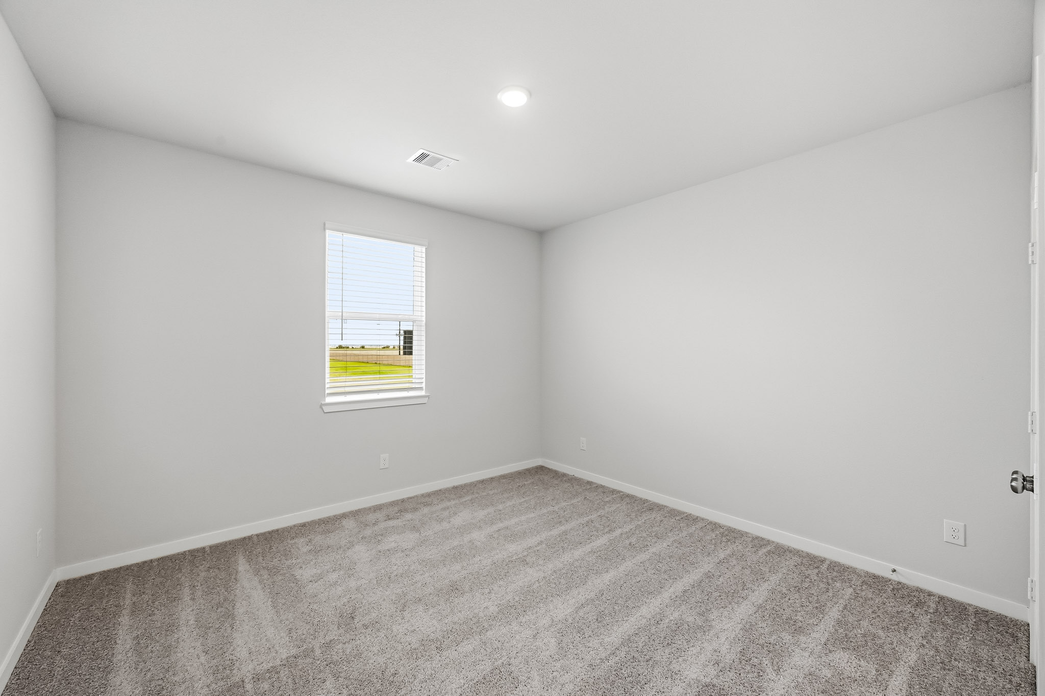 A room with a carpet and a window.