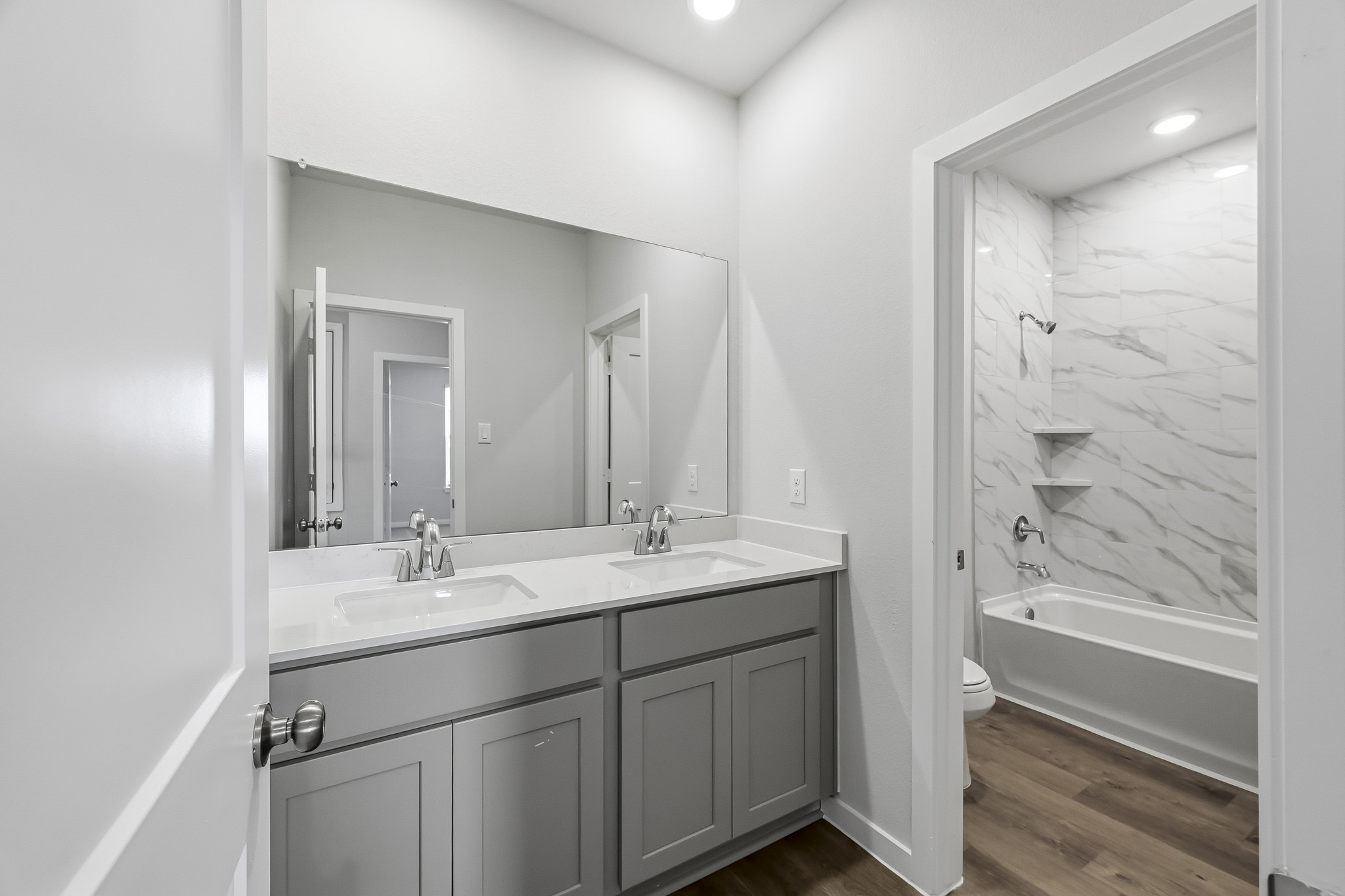 A bathroom with a tub sink and a mirror.