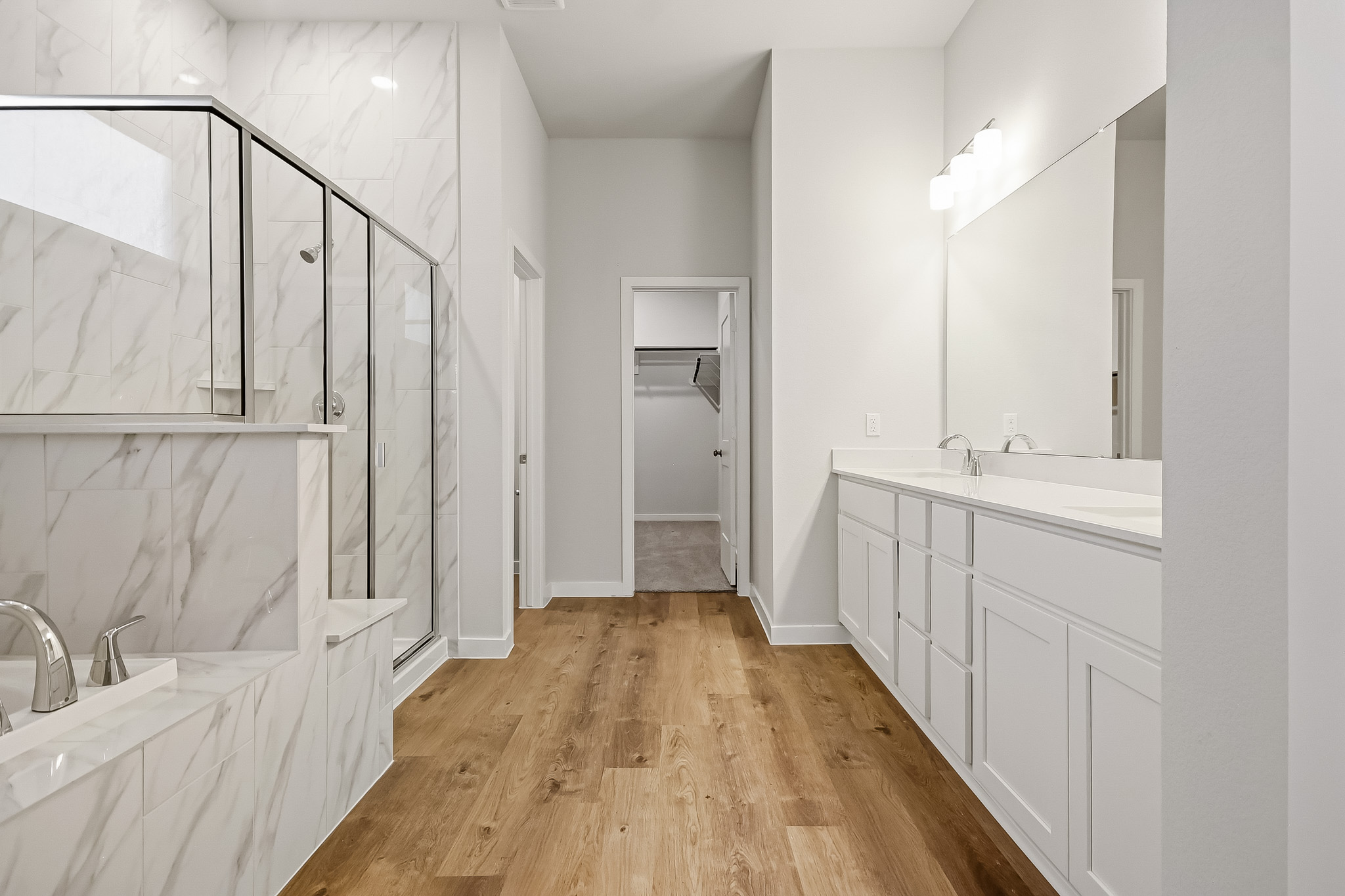 A bathroom with white cabinets.