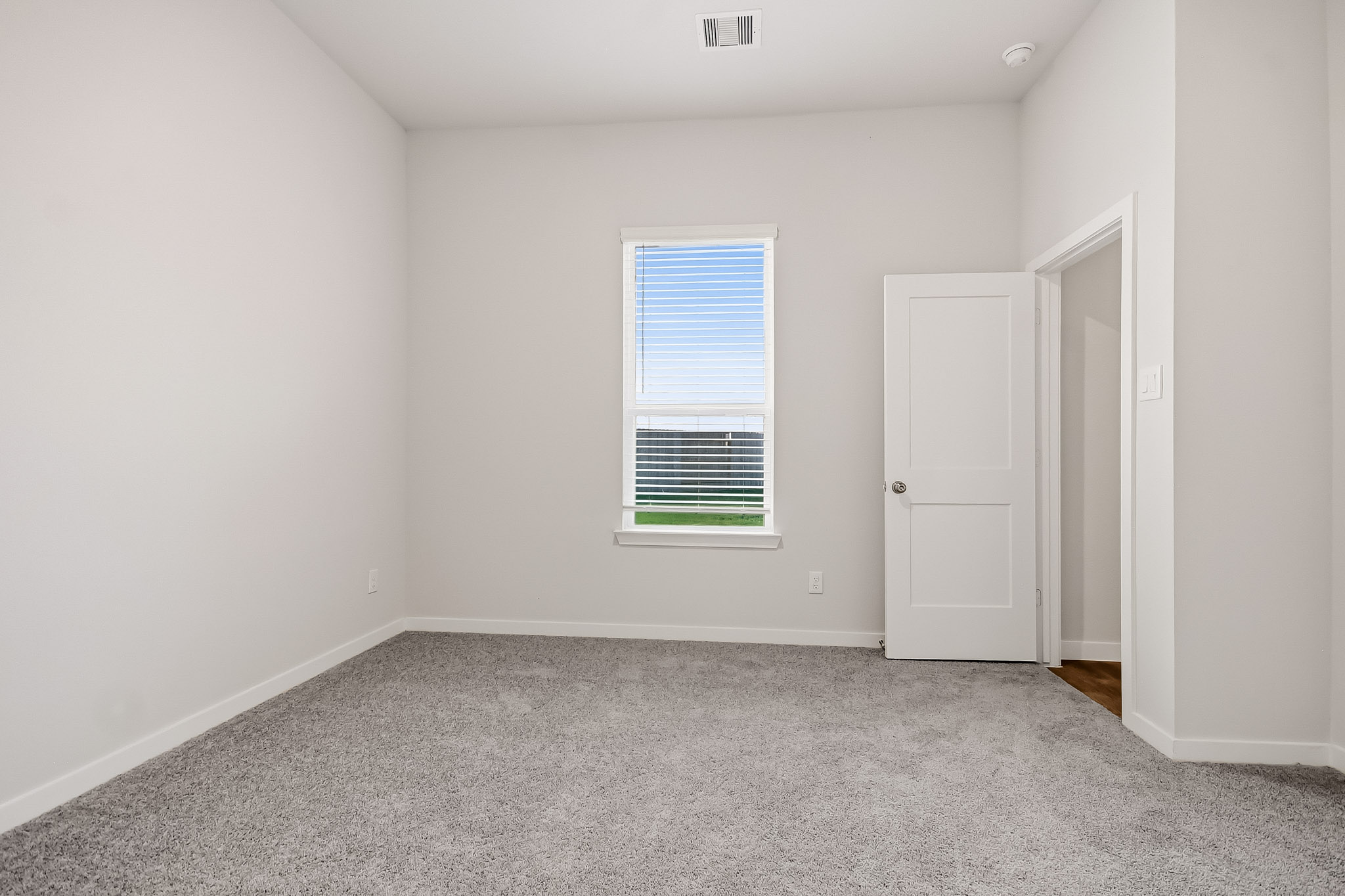 A room with white walls and a window.