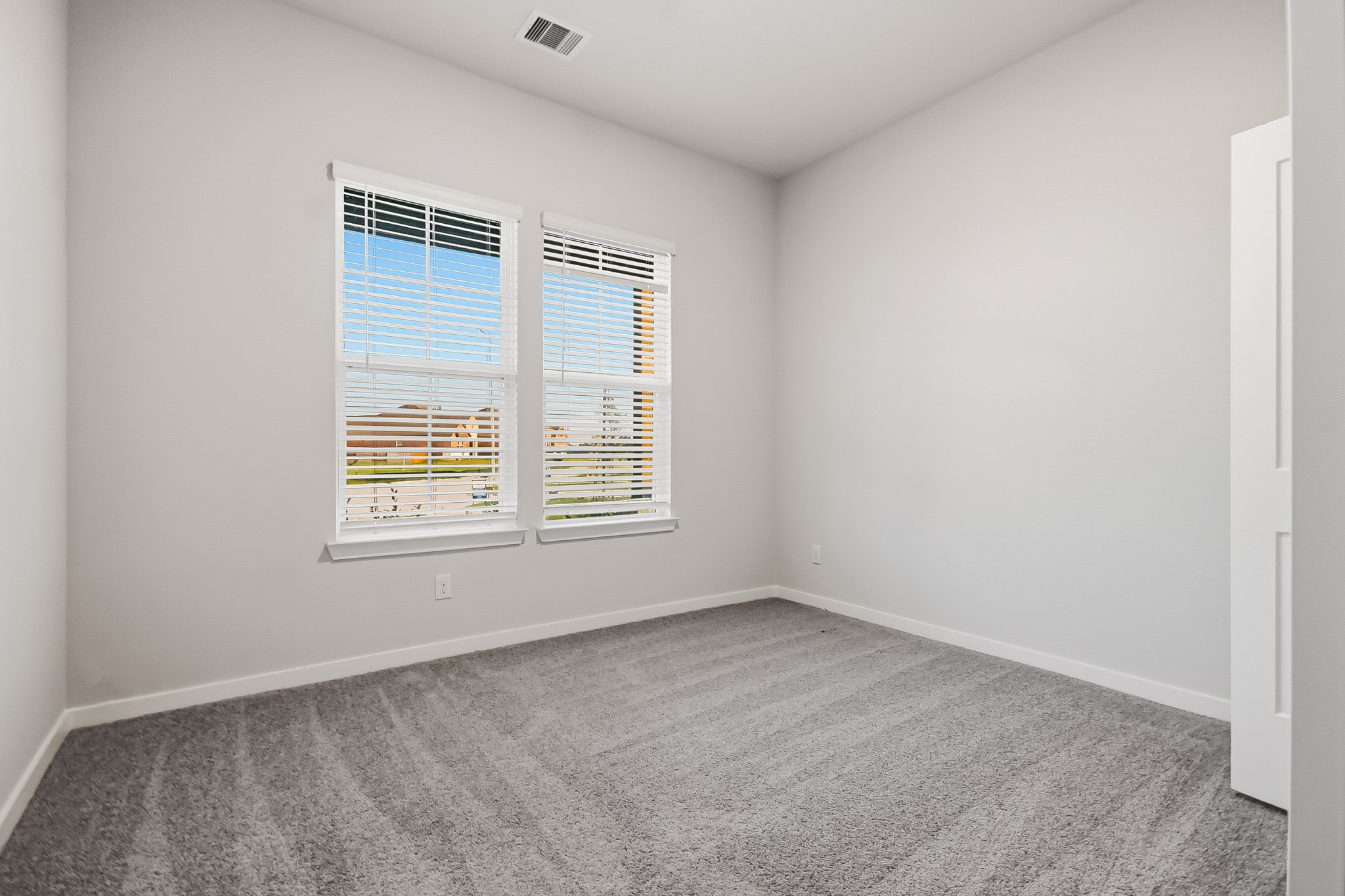 A room with a window and a carpet.