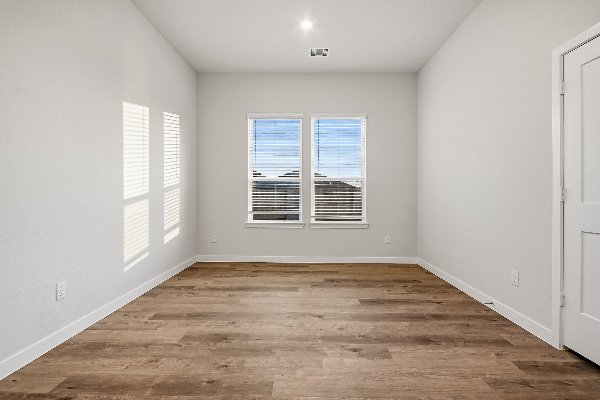 A room with white walls and a wood floor.