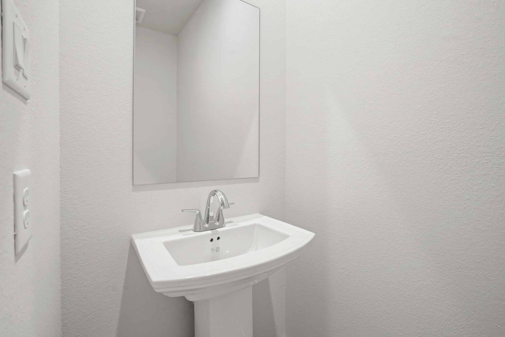 A bathroom with a mirror and sink.