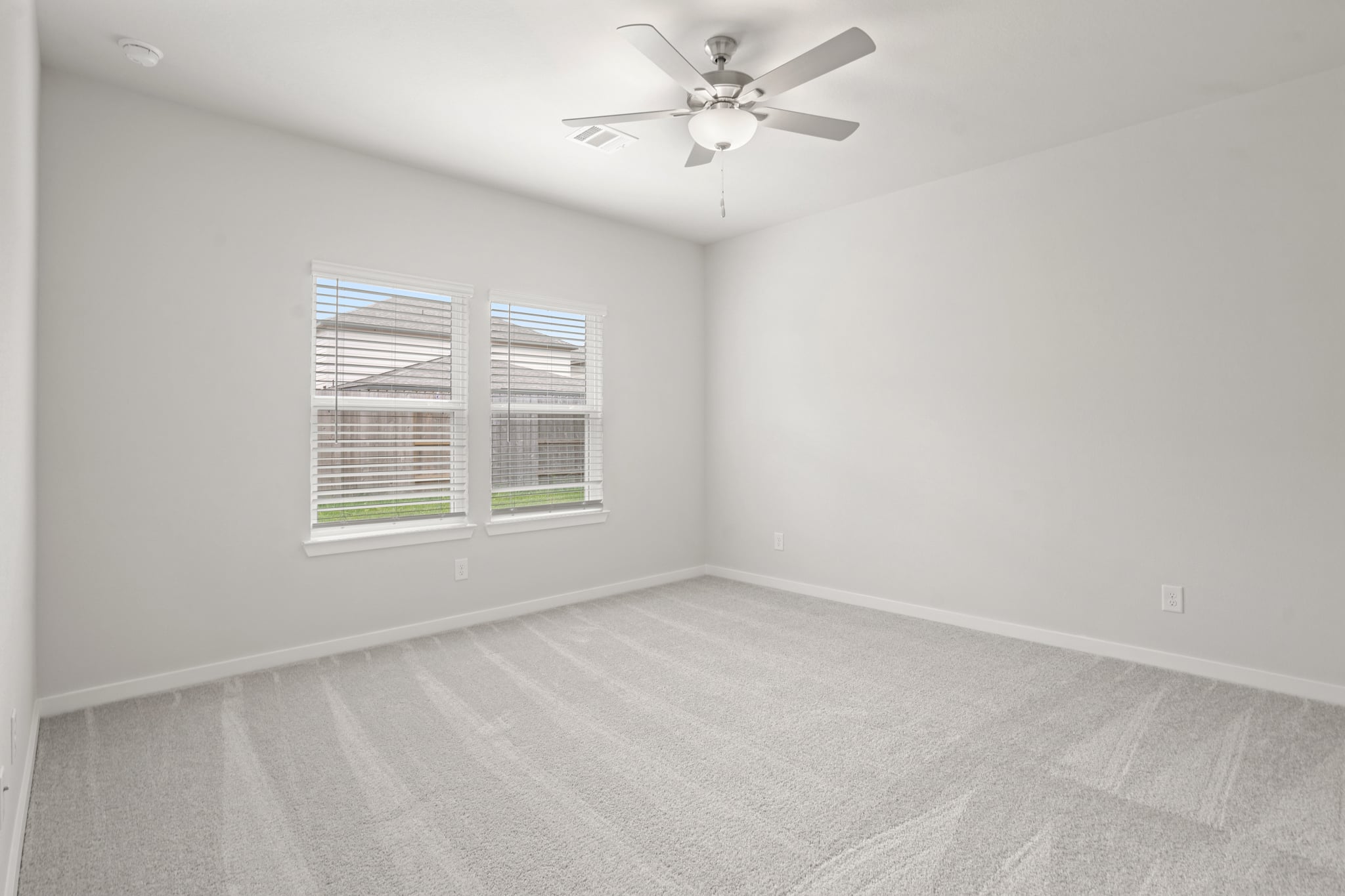 A room with a ceiling fan and a window.
