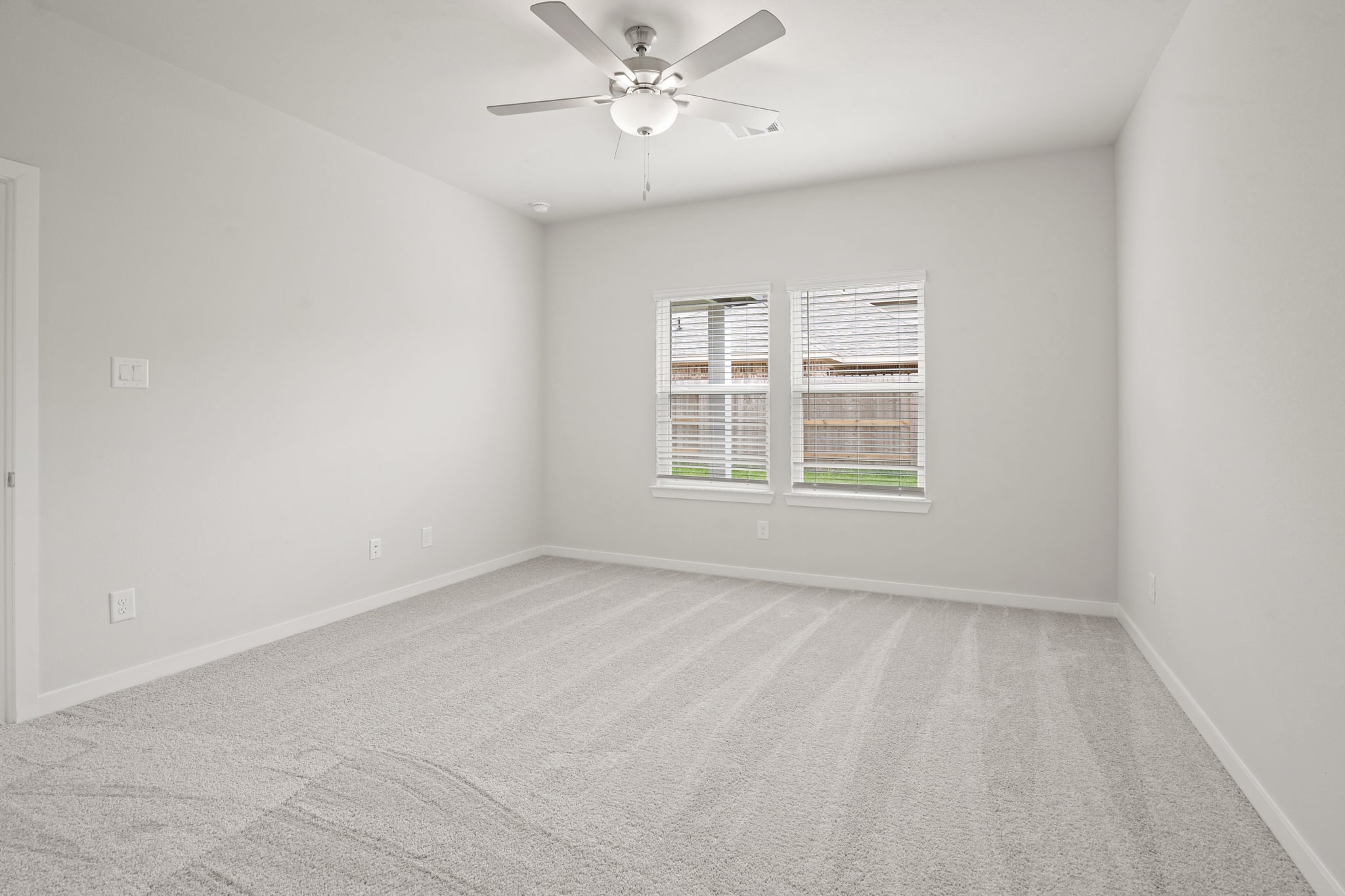 A room with a ceiling fan and a window.