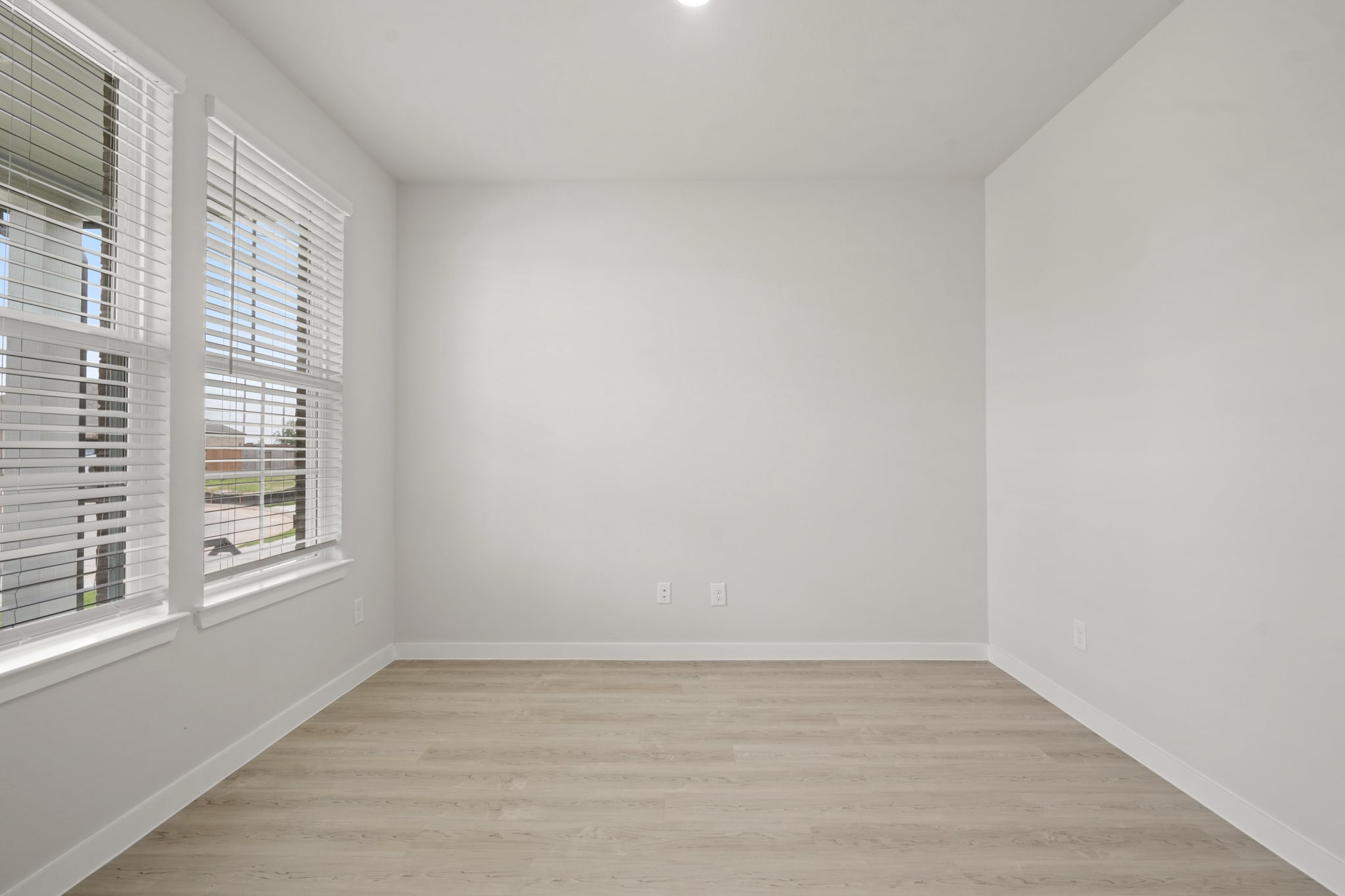 A room with a wood floor and windows.