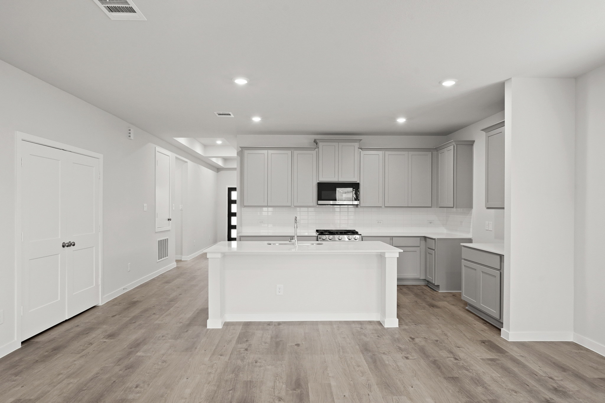 A kitchen with white cabinets.