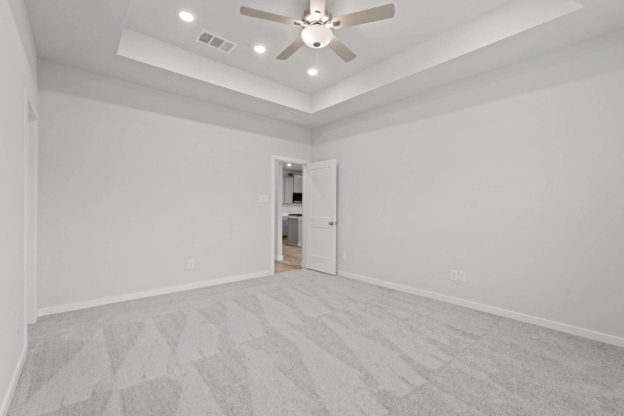 A room with a ceiling fan and a door.