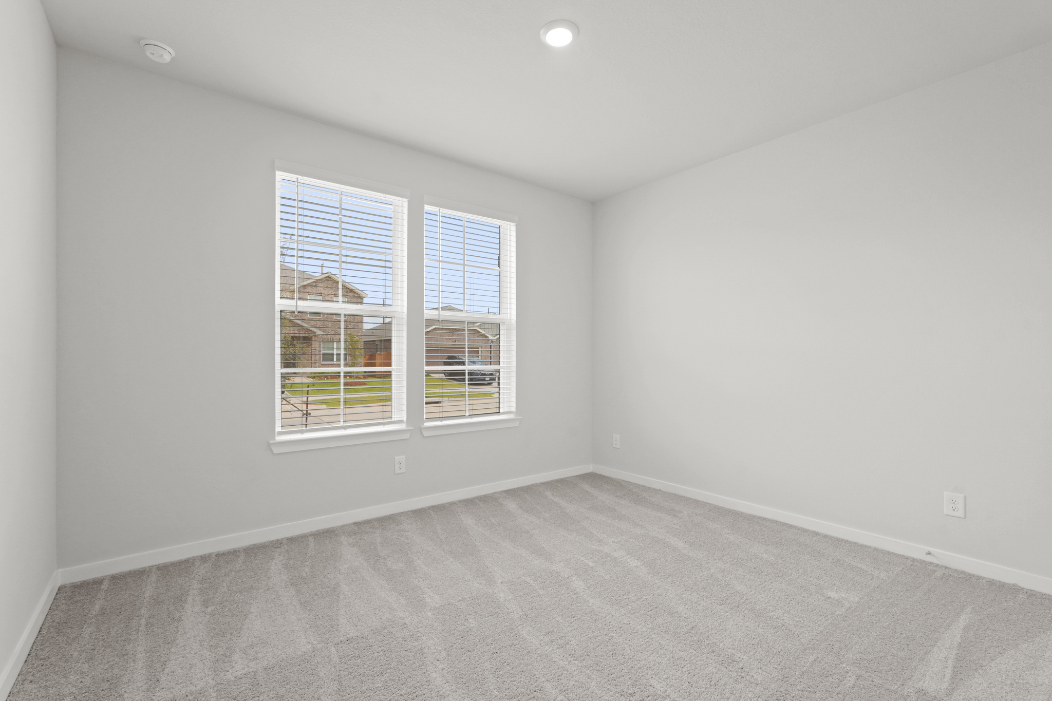 A room with a window and a white wall.