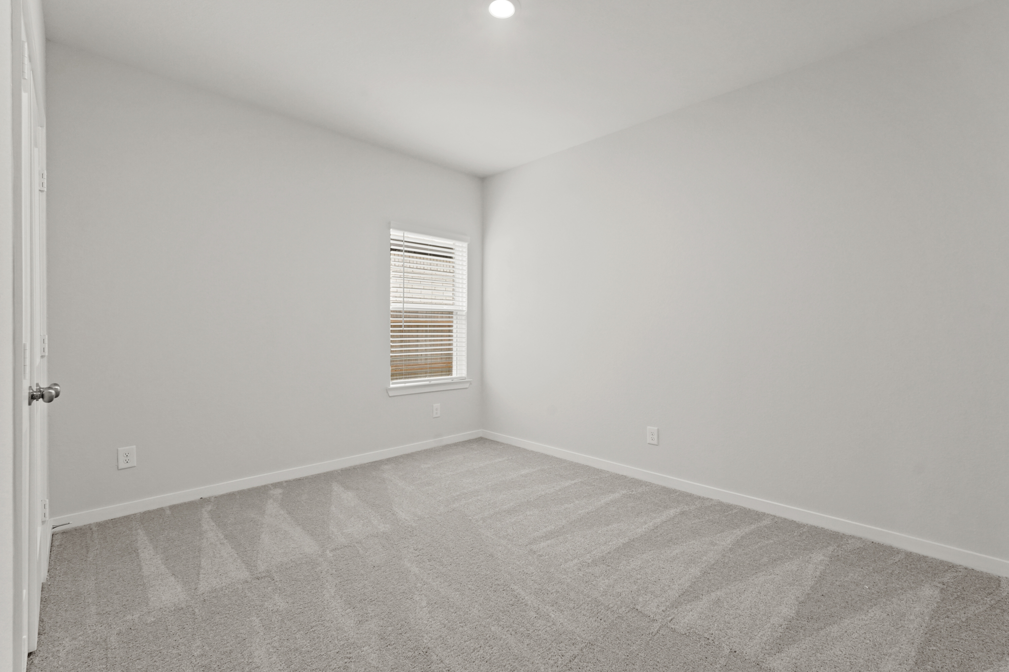 A room with a carpet and a window.