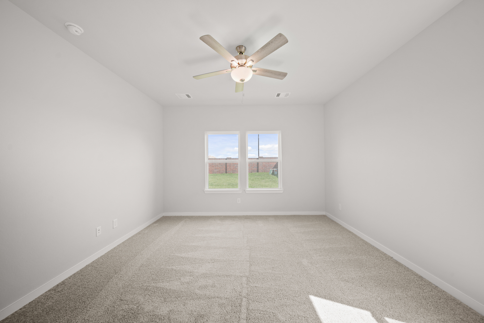 A room with a ceiling fan and a window.