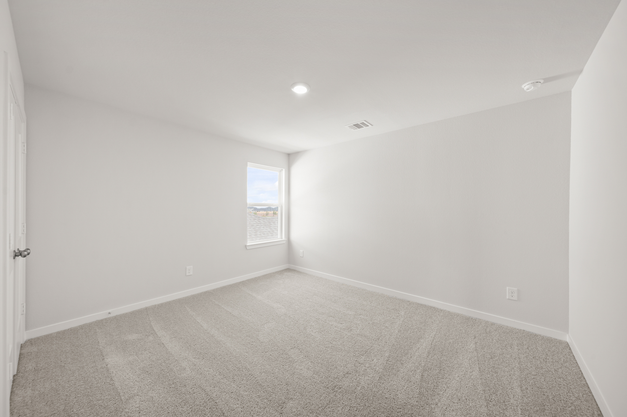 A room with a carpet and a door.