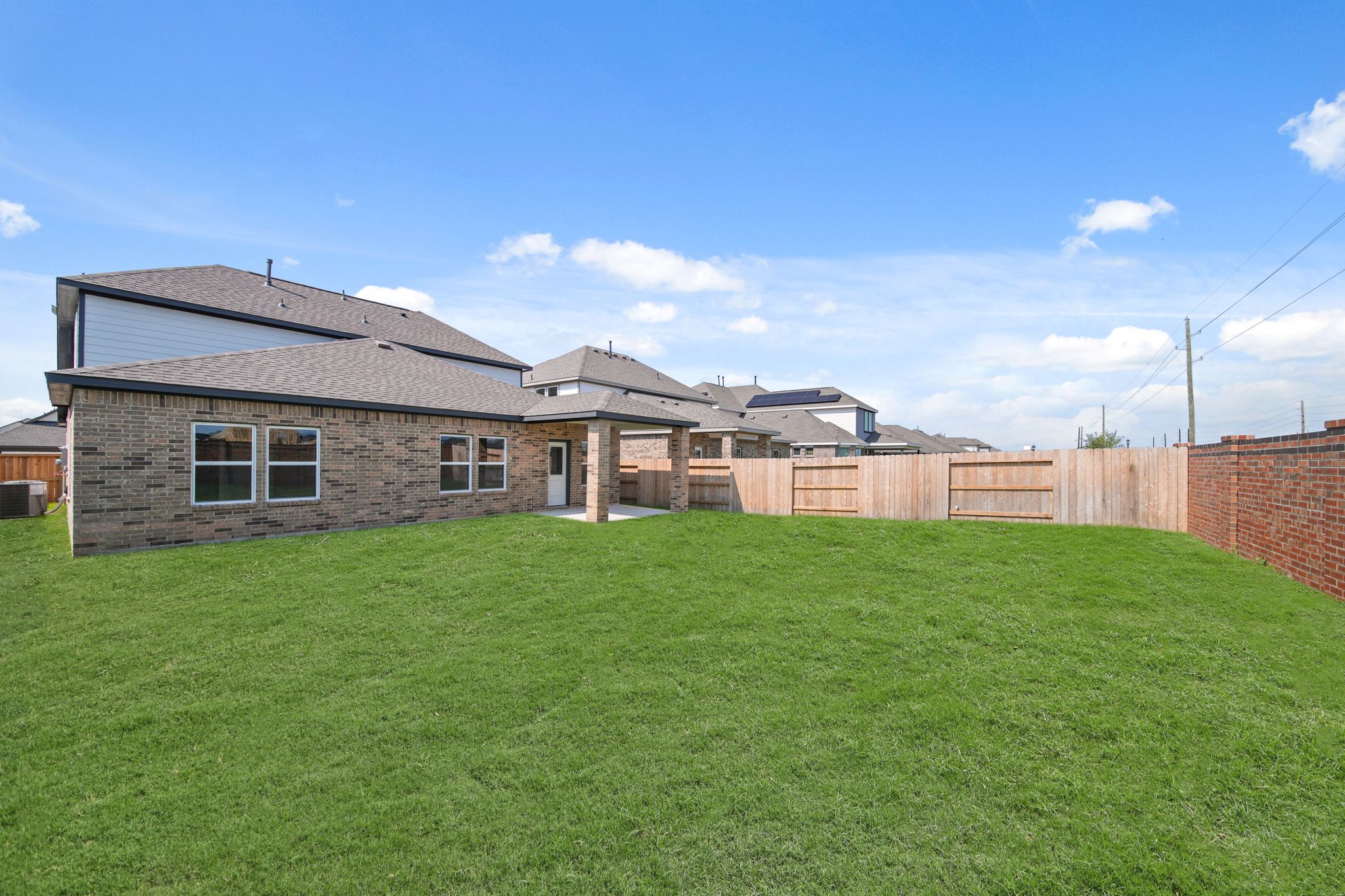 A large green lawn in front of a brick building.