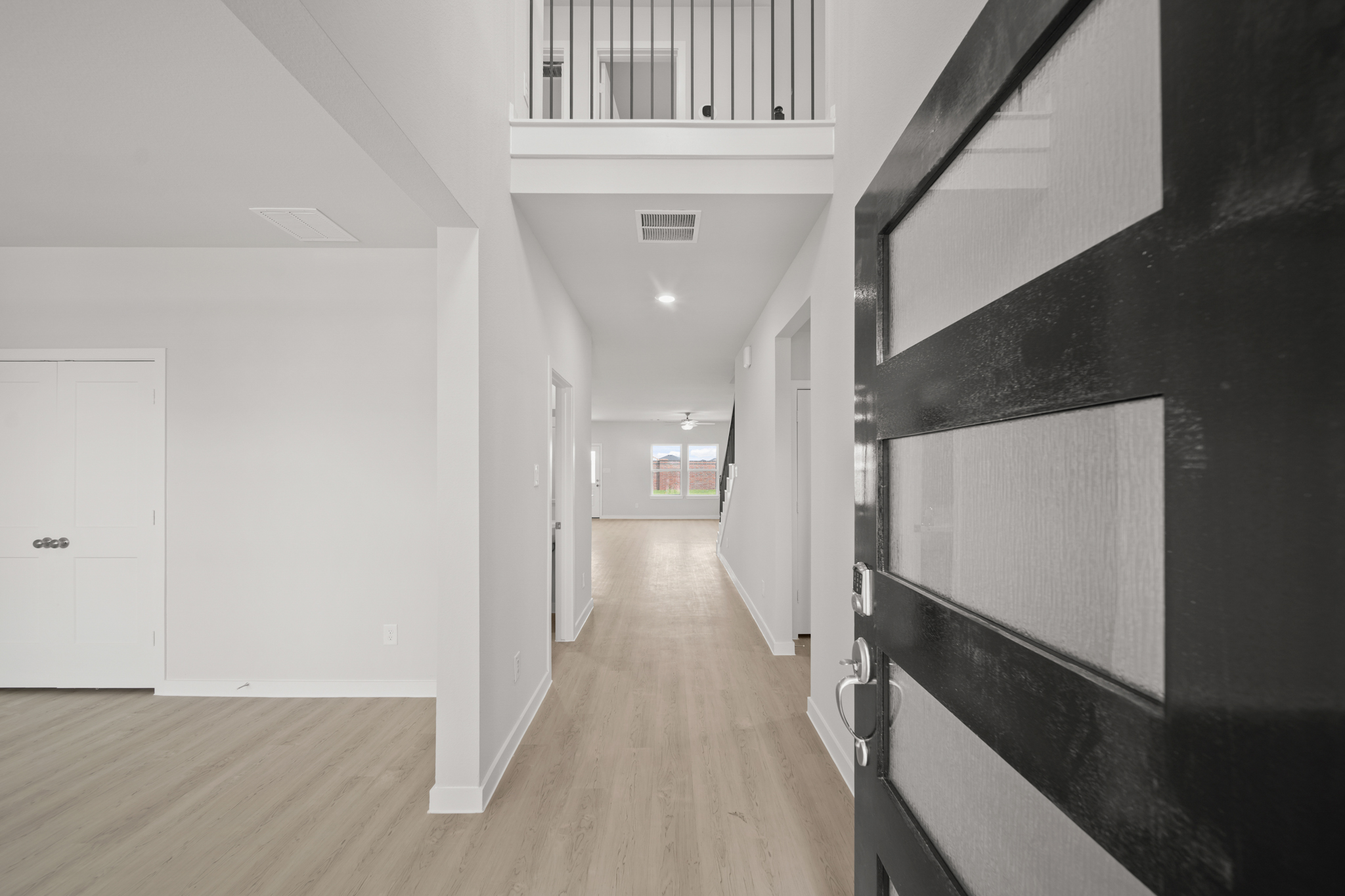 A hallway with white cabinets.