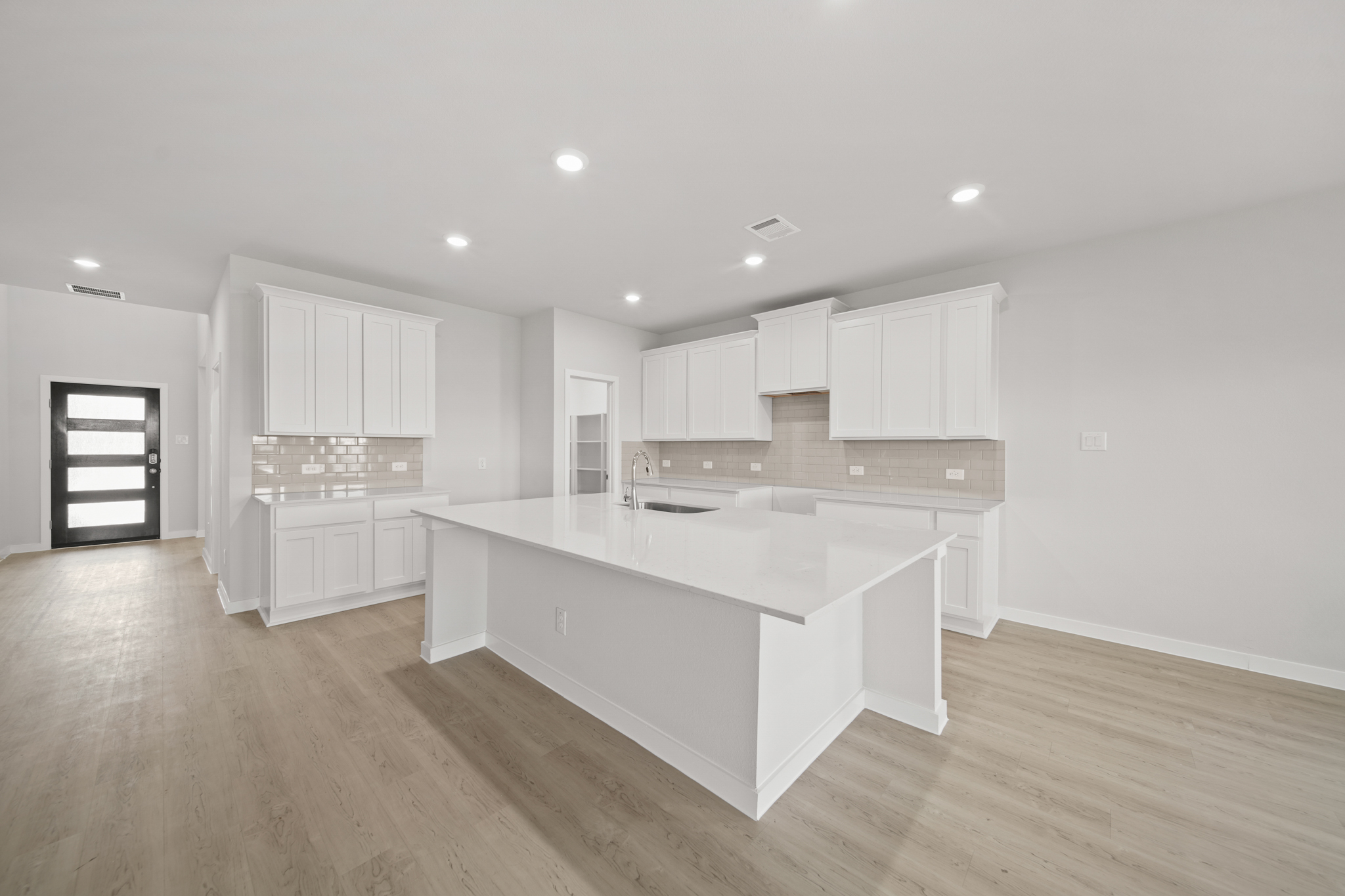 A kitchen with white cabinets.