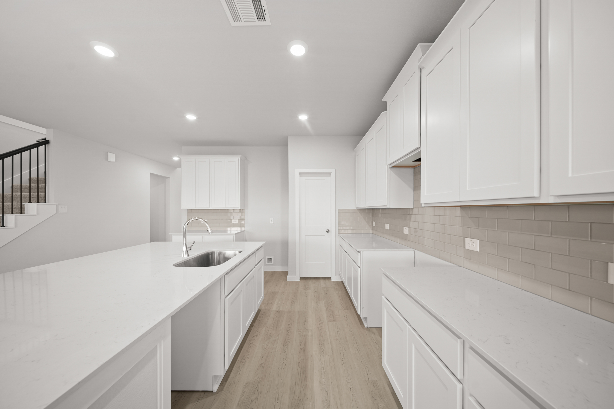 A kitchen with white cabinets.