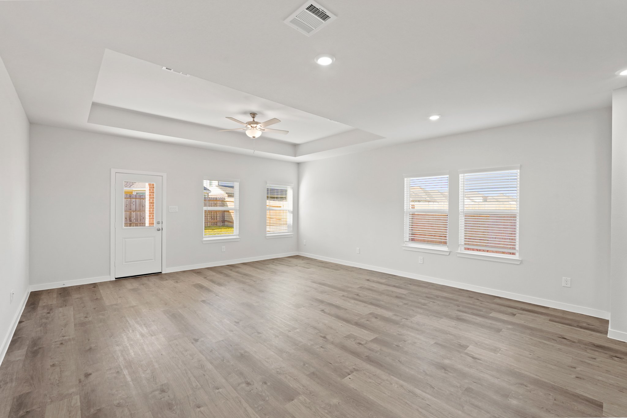 A room with a wood floor and a ceiling fan.