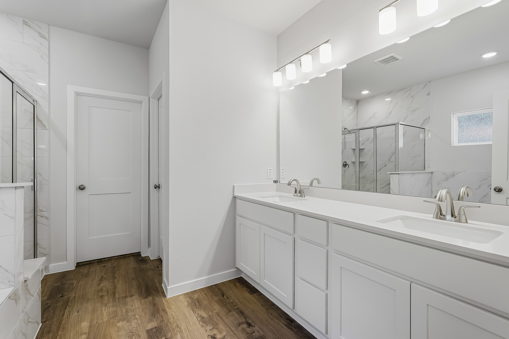 A bathroom with white cabinets.