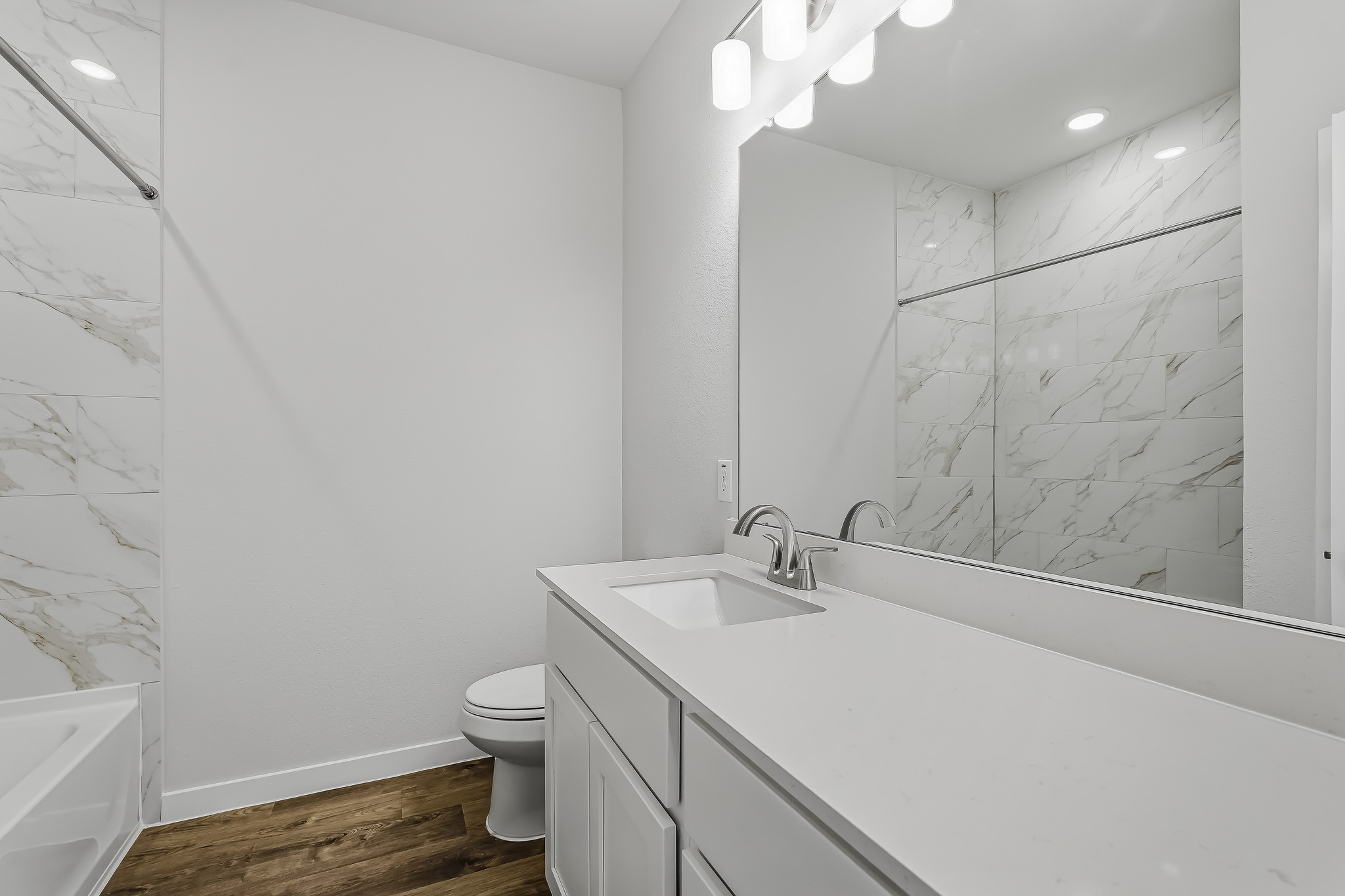 A bathroom with a tub sink and toilet.
