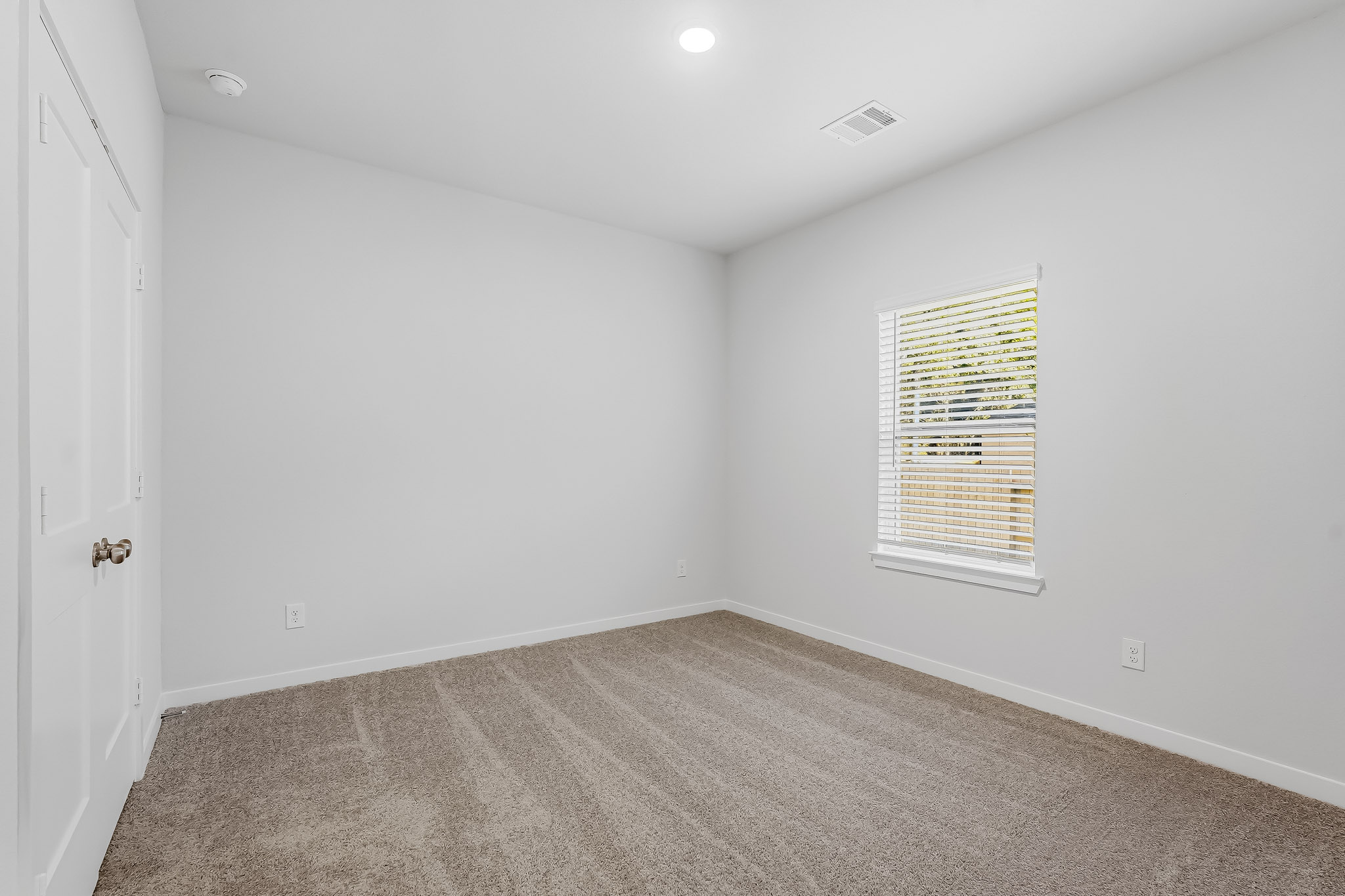 A room with a carpet and a window.