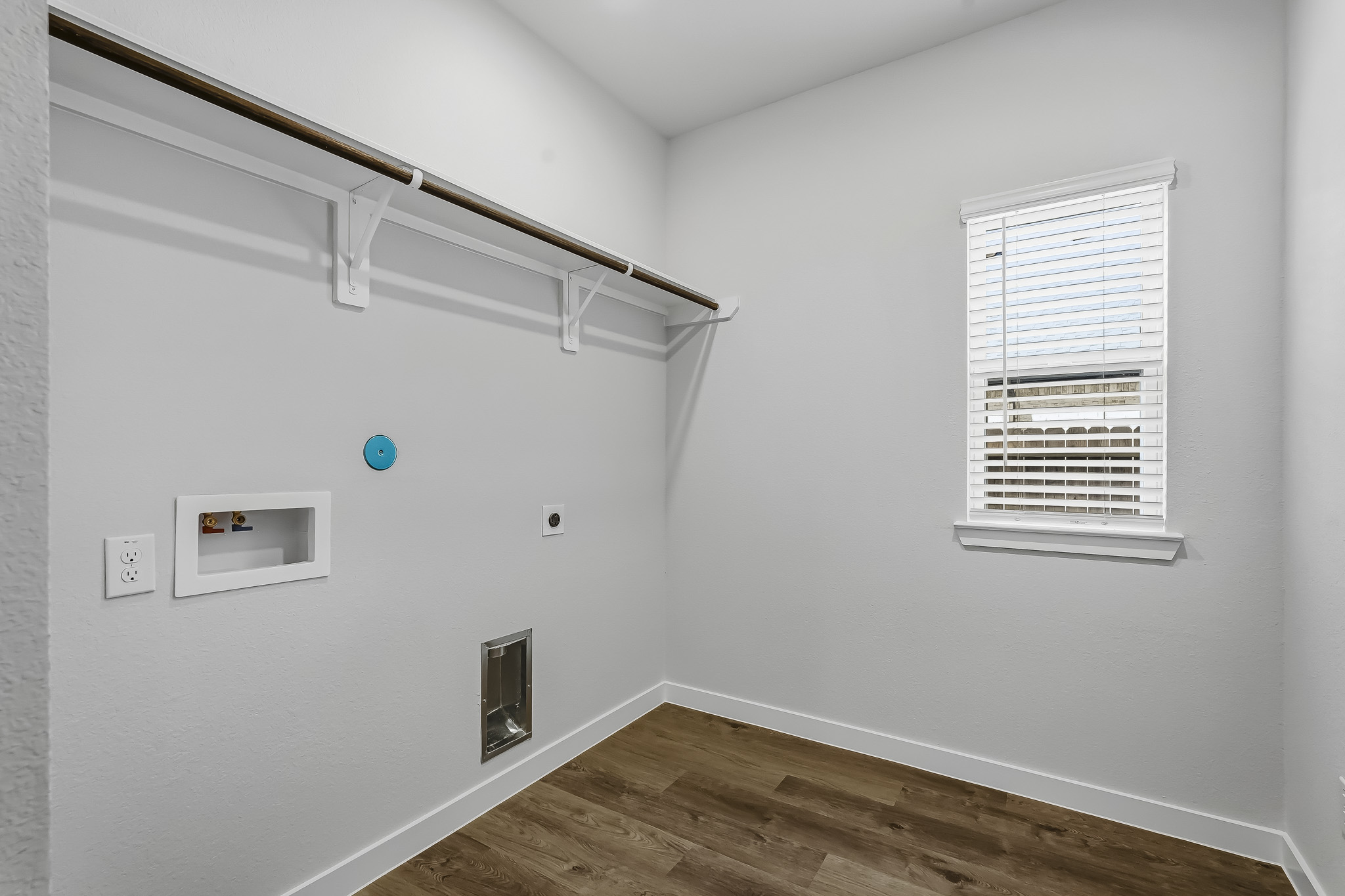A room with a wood floor and a wood floor with a window.