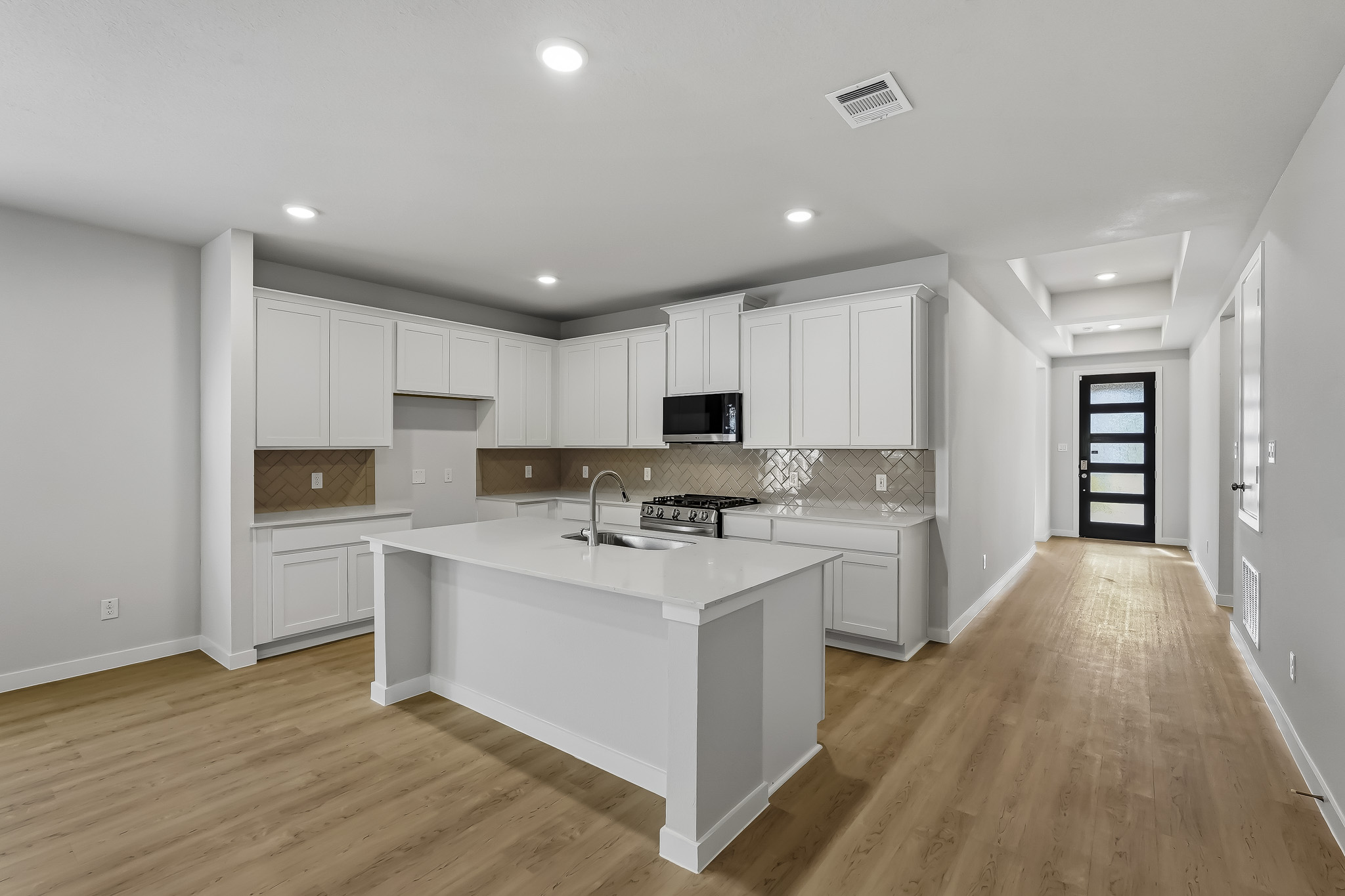 A kitchen with white cabinets.