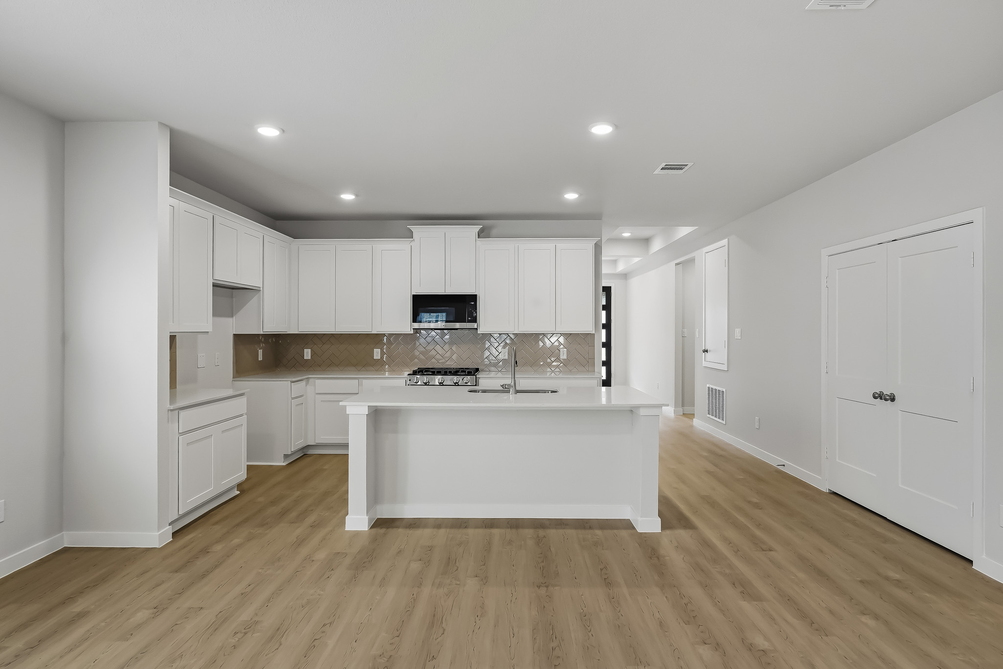 A kitchen with white cabinets.