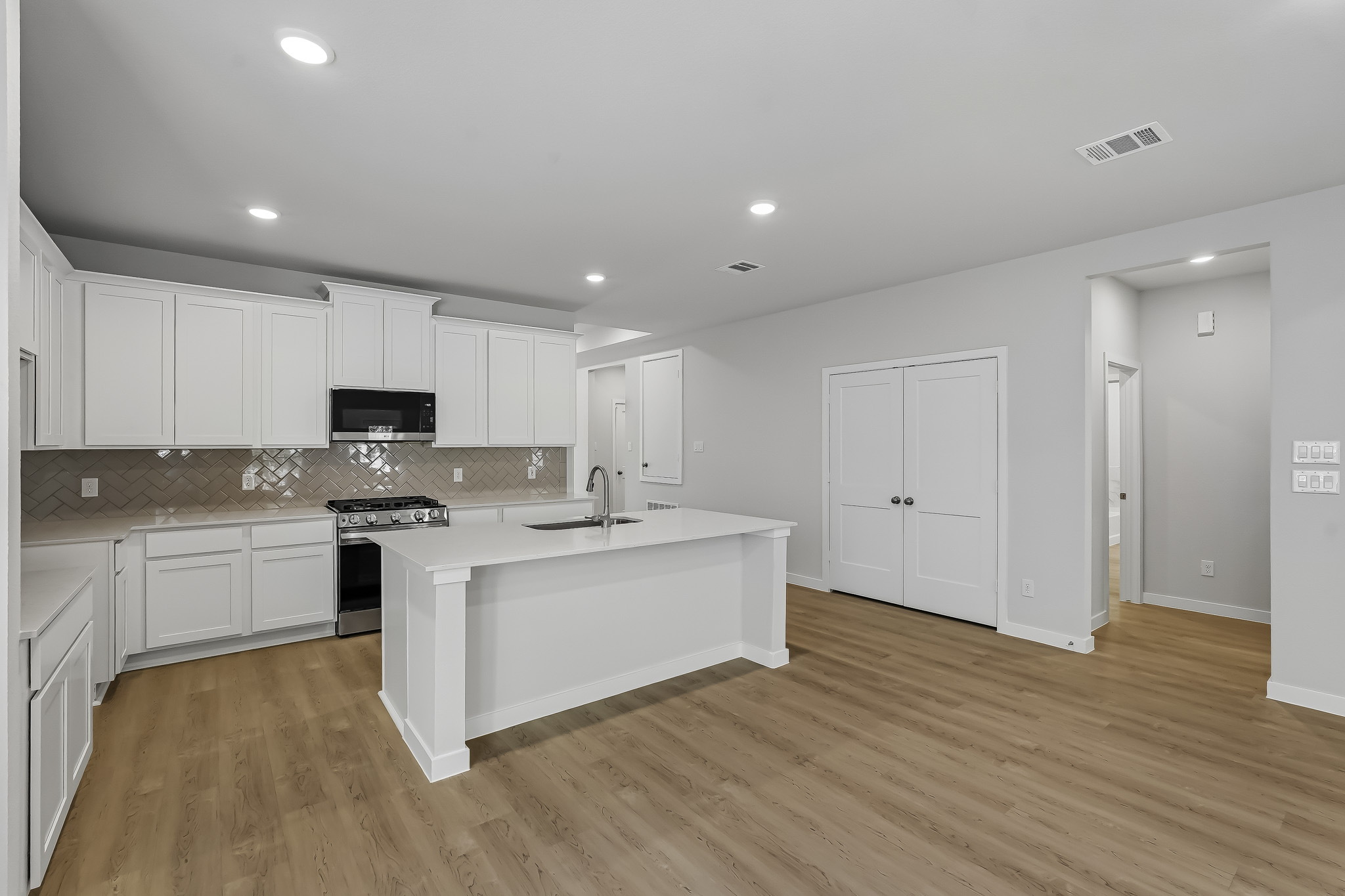 A kitchen with white cabinets.