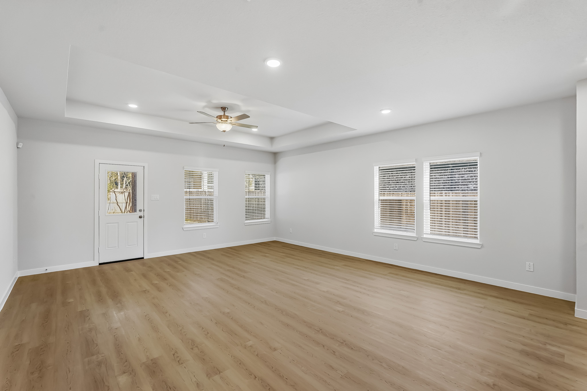 A room with a wood floor and a ceiling fan.