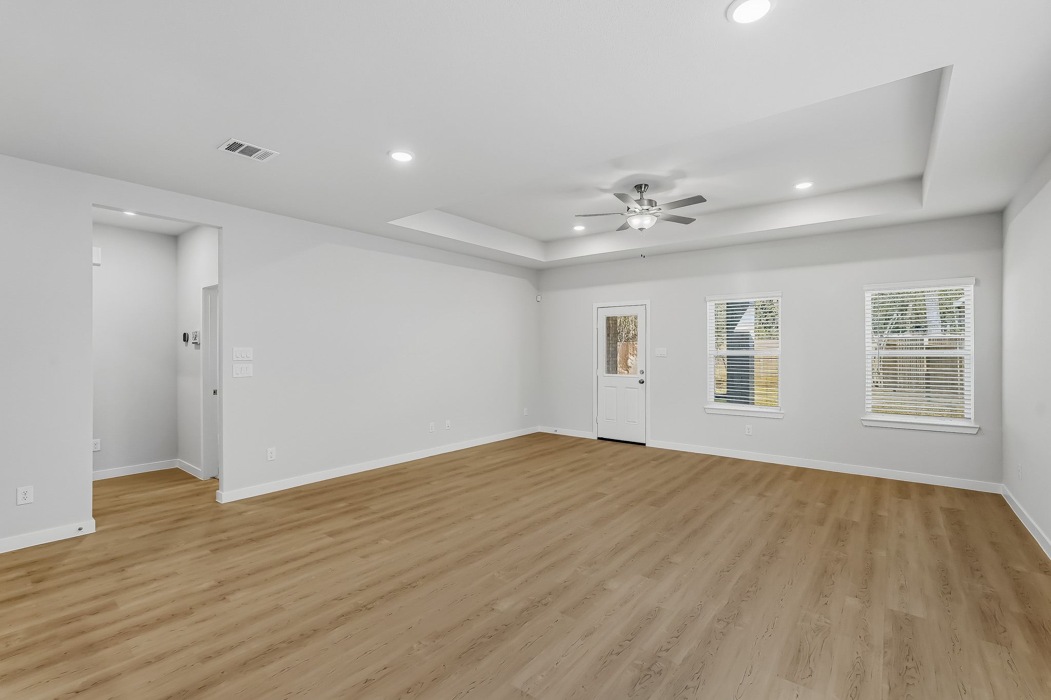 A room with a wood floor and white walls.