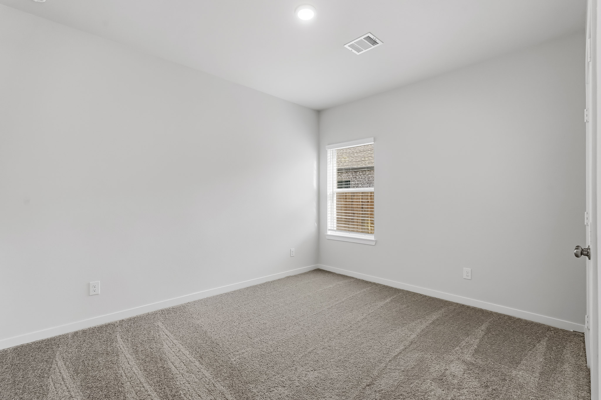 A room with a window and carpet.
