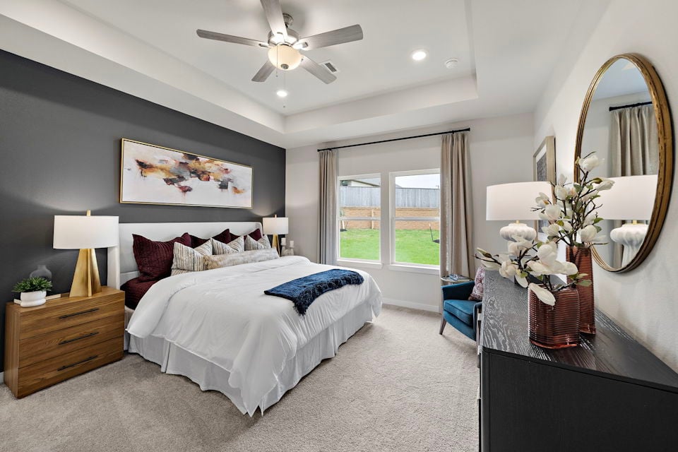 A bedroom with a large mirror.