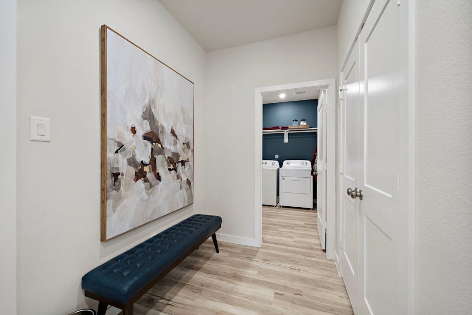 A room with a bench and a painting on the wall.