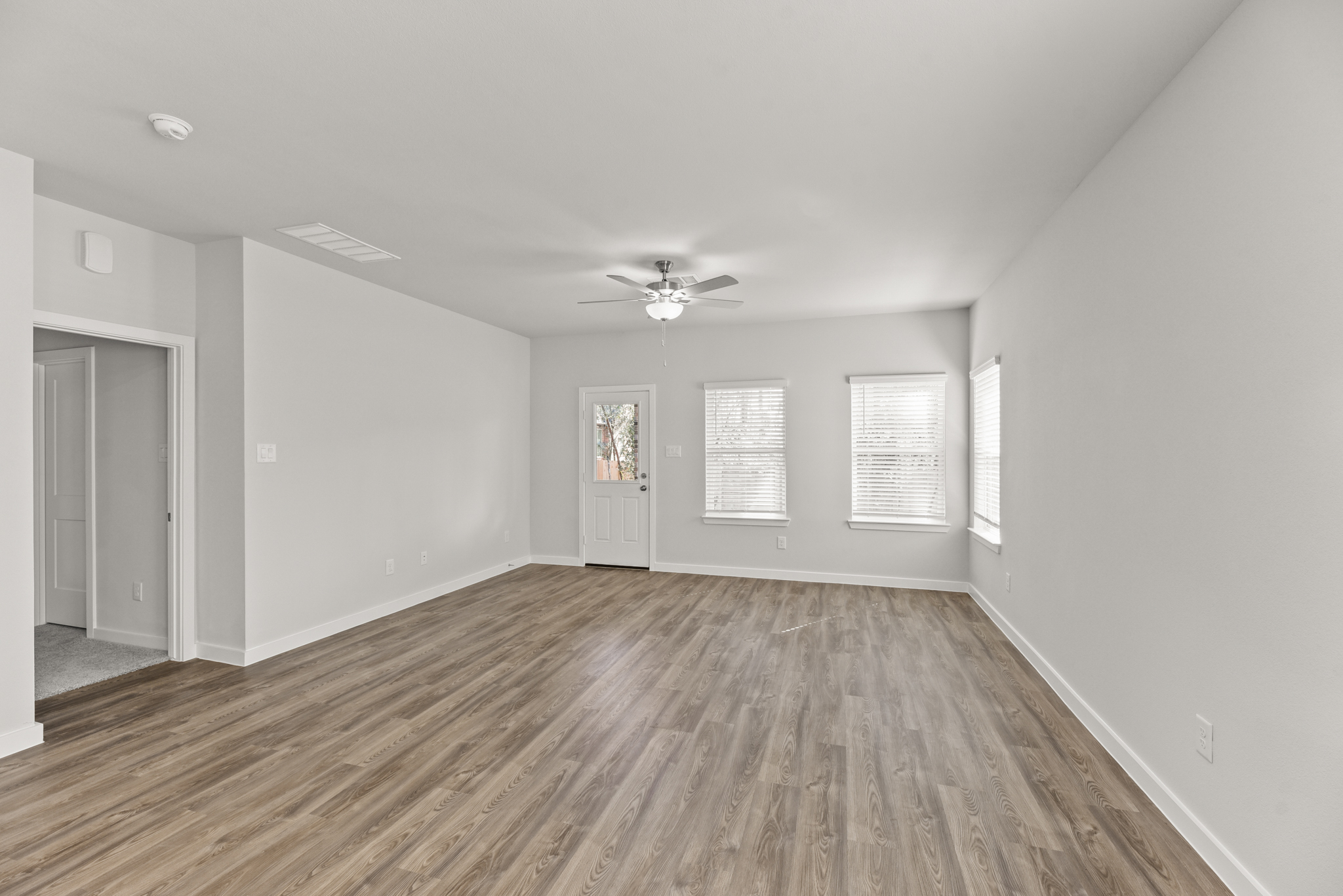A room with a wood floor and a ceiling fan.