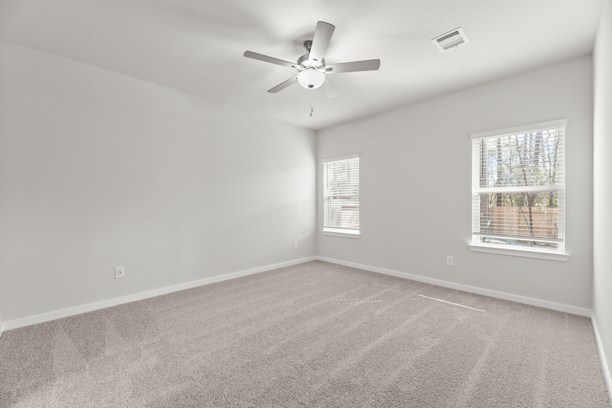 A room with a ceiling fan and a window.