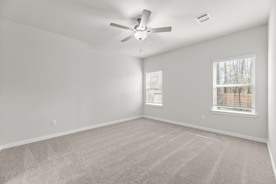 A room with a ceiling fan and a window.