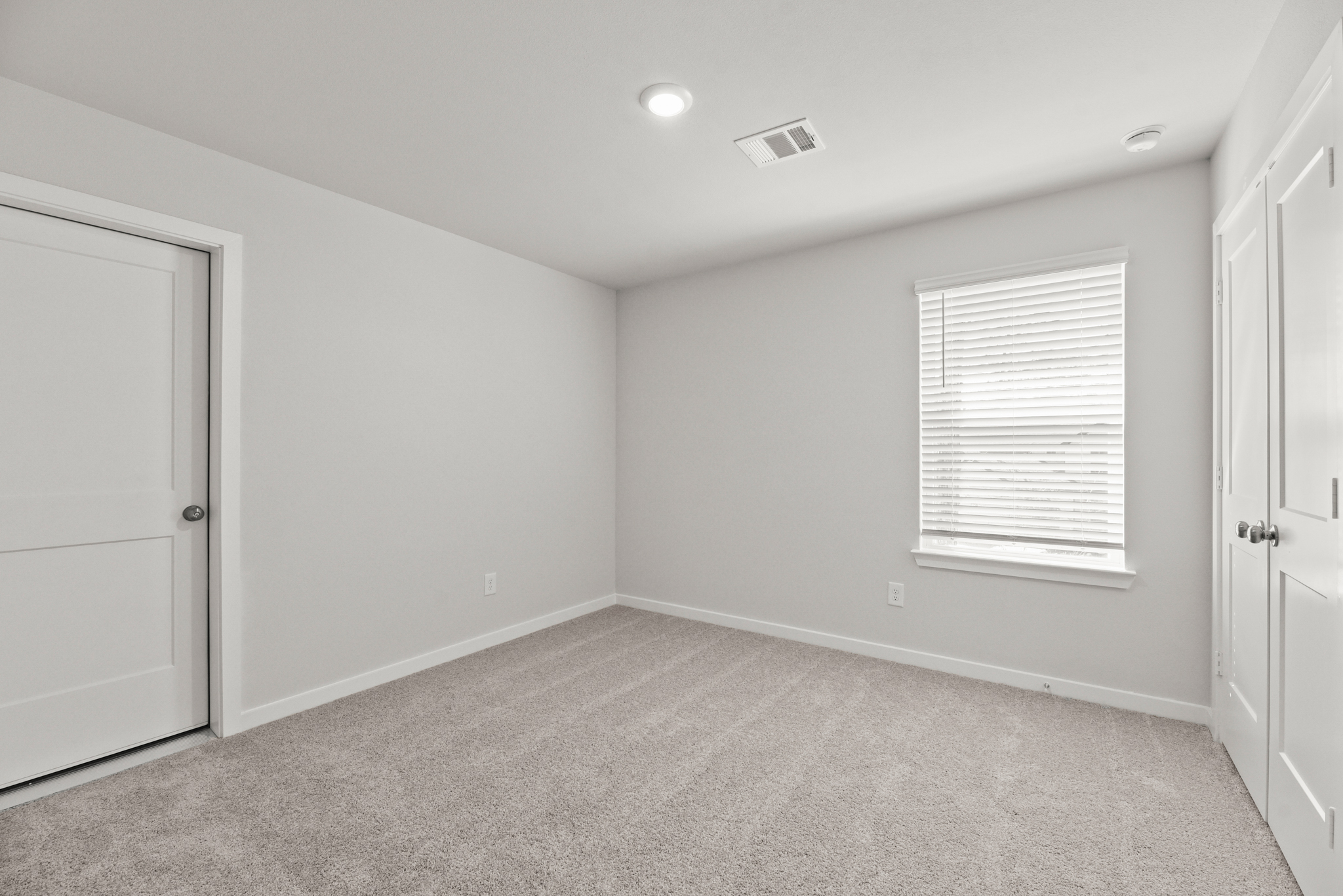 A room with white walls and a carpet.
