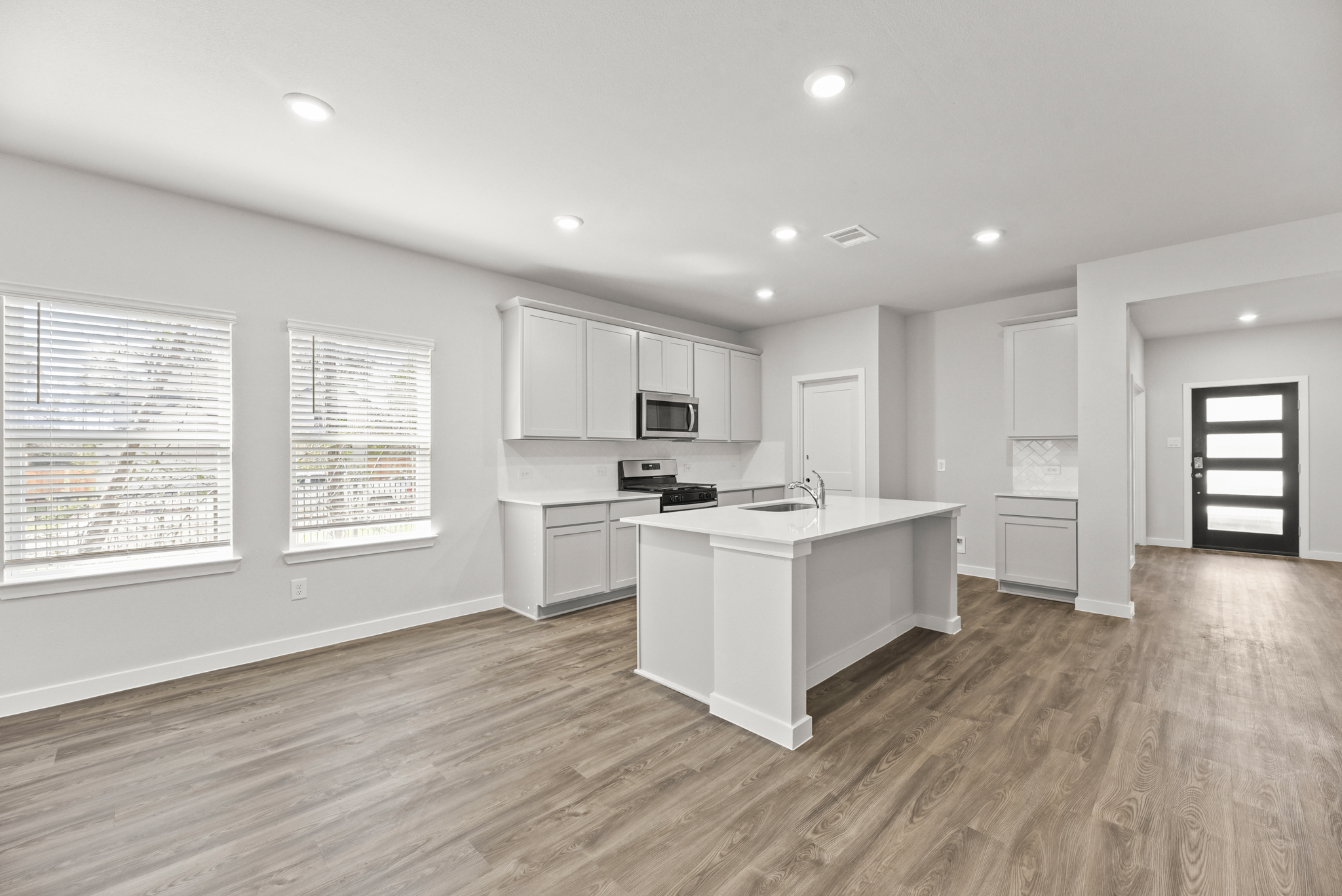A kitchen with white cabinets.