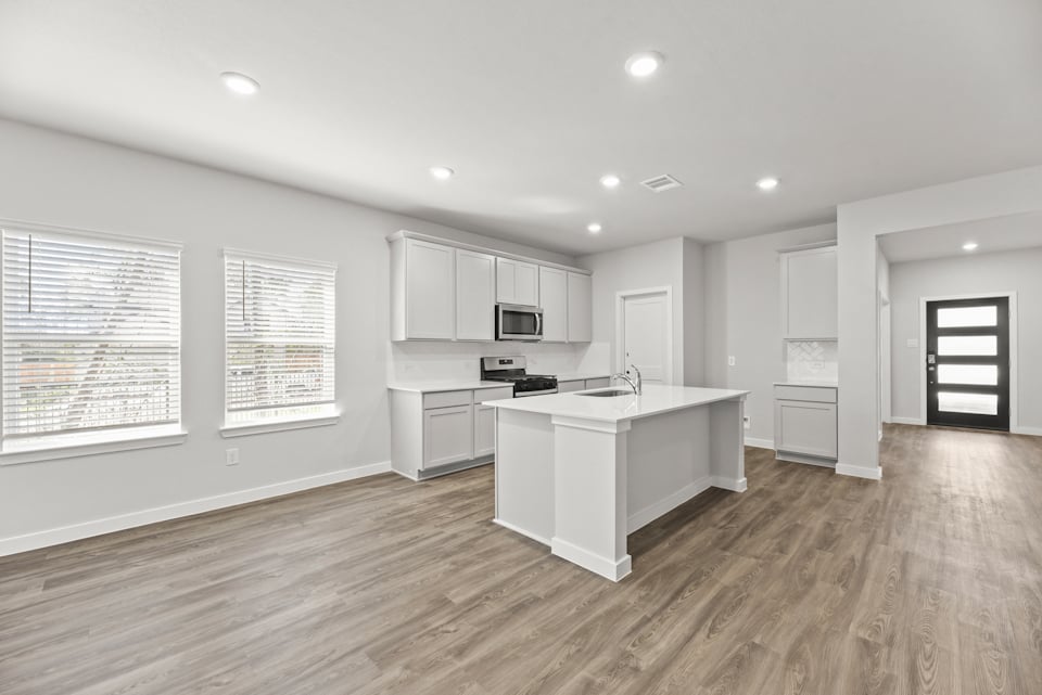A kitchen with white cabinets.
