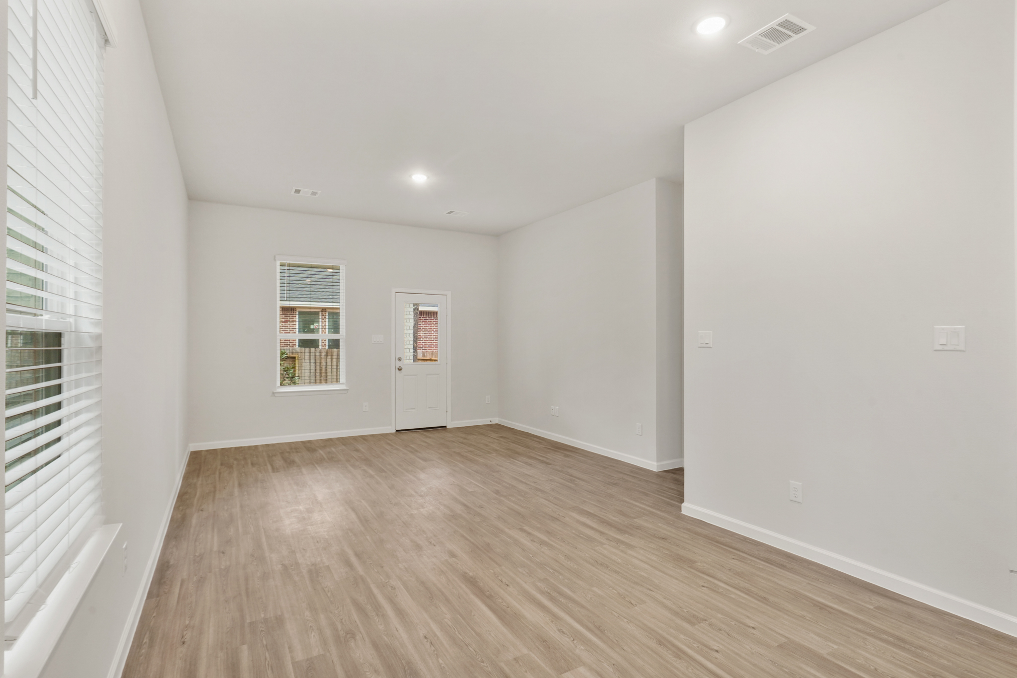 A room with a wood floor and white walls.