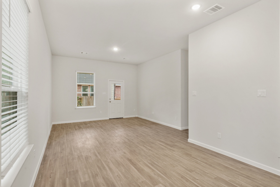 A room with a wood floor and white walls.