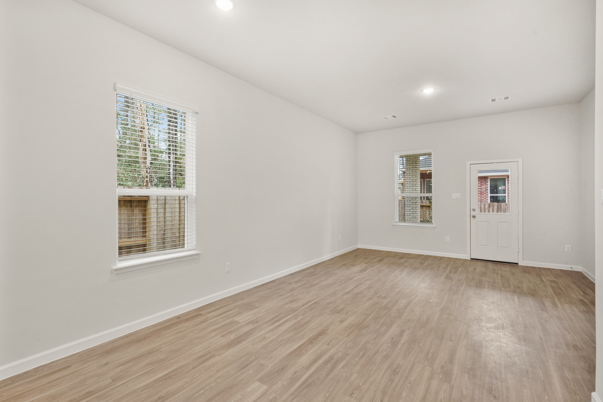 A room with a wood floor and a white door.