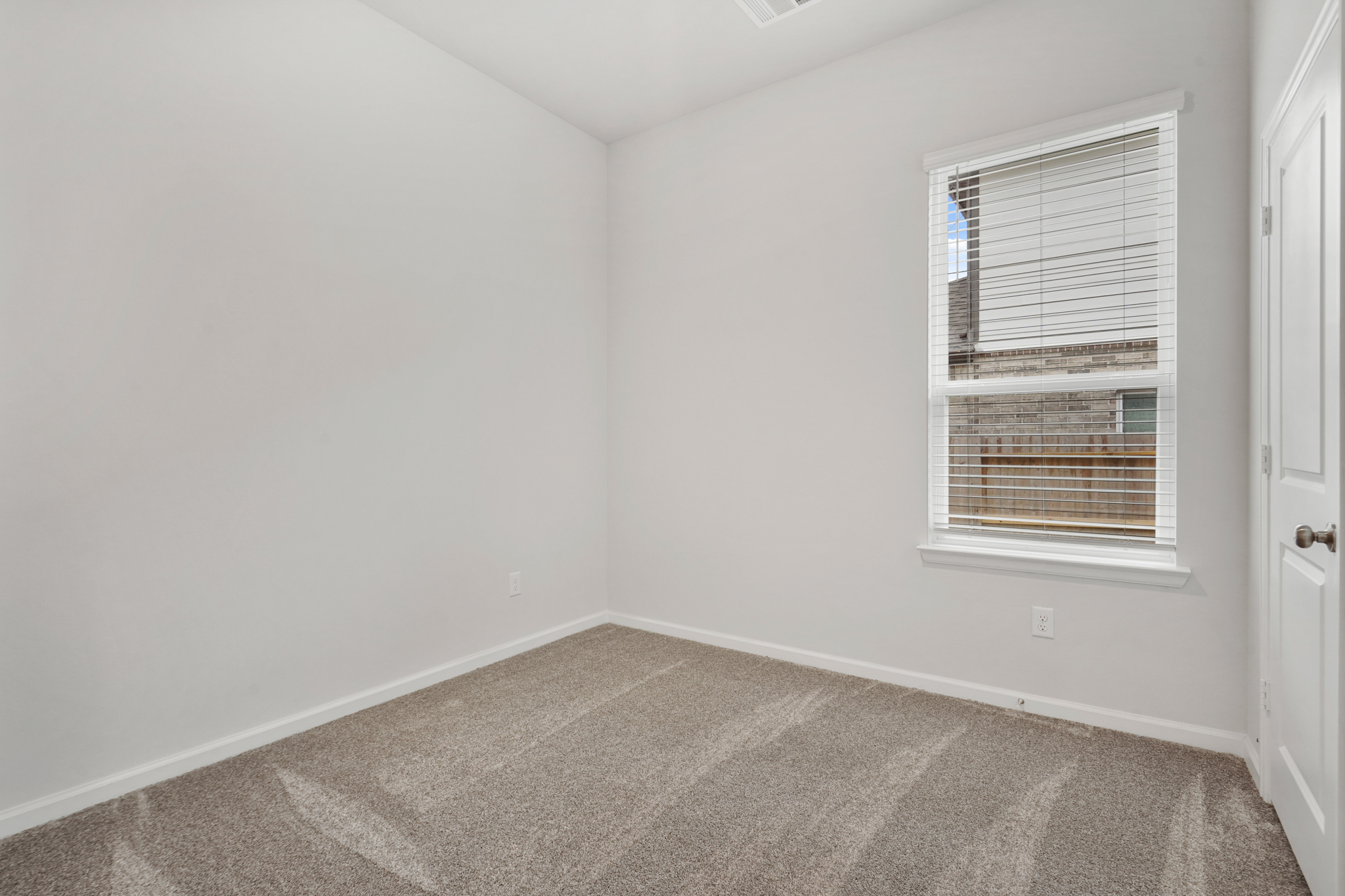 A room with a window and carpet.