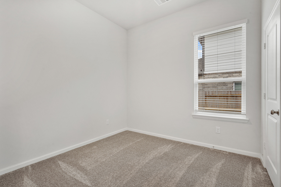 A room with a window and carpet.