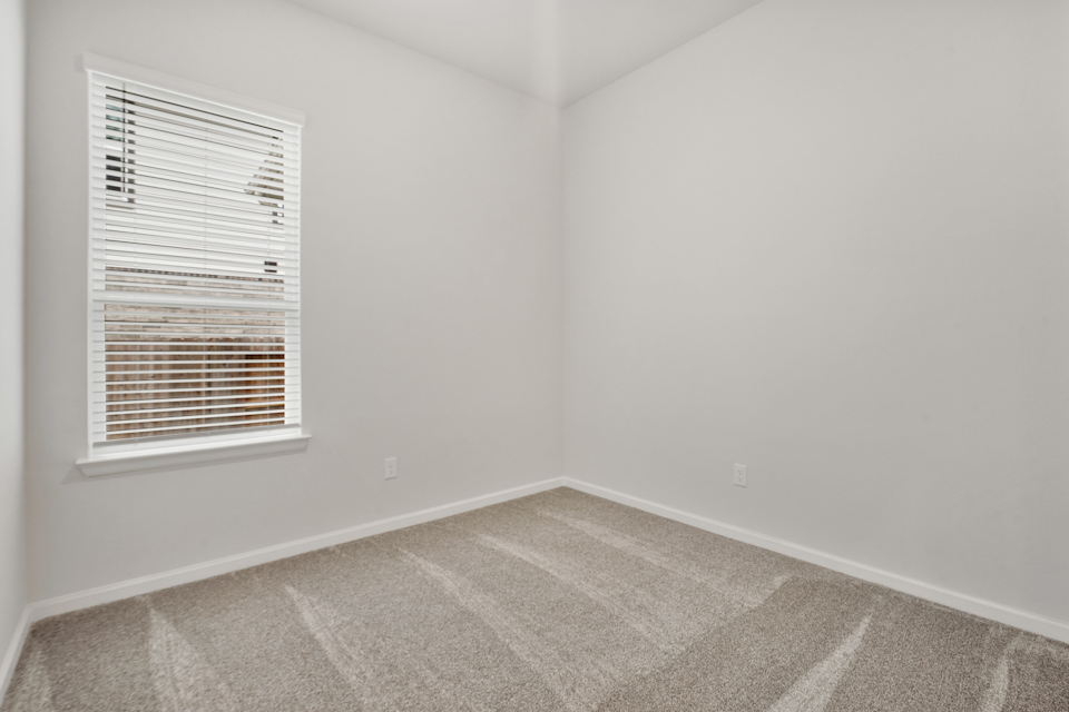 A room with a window and carpet.