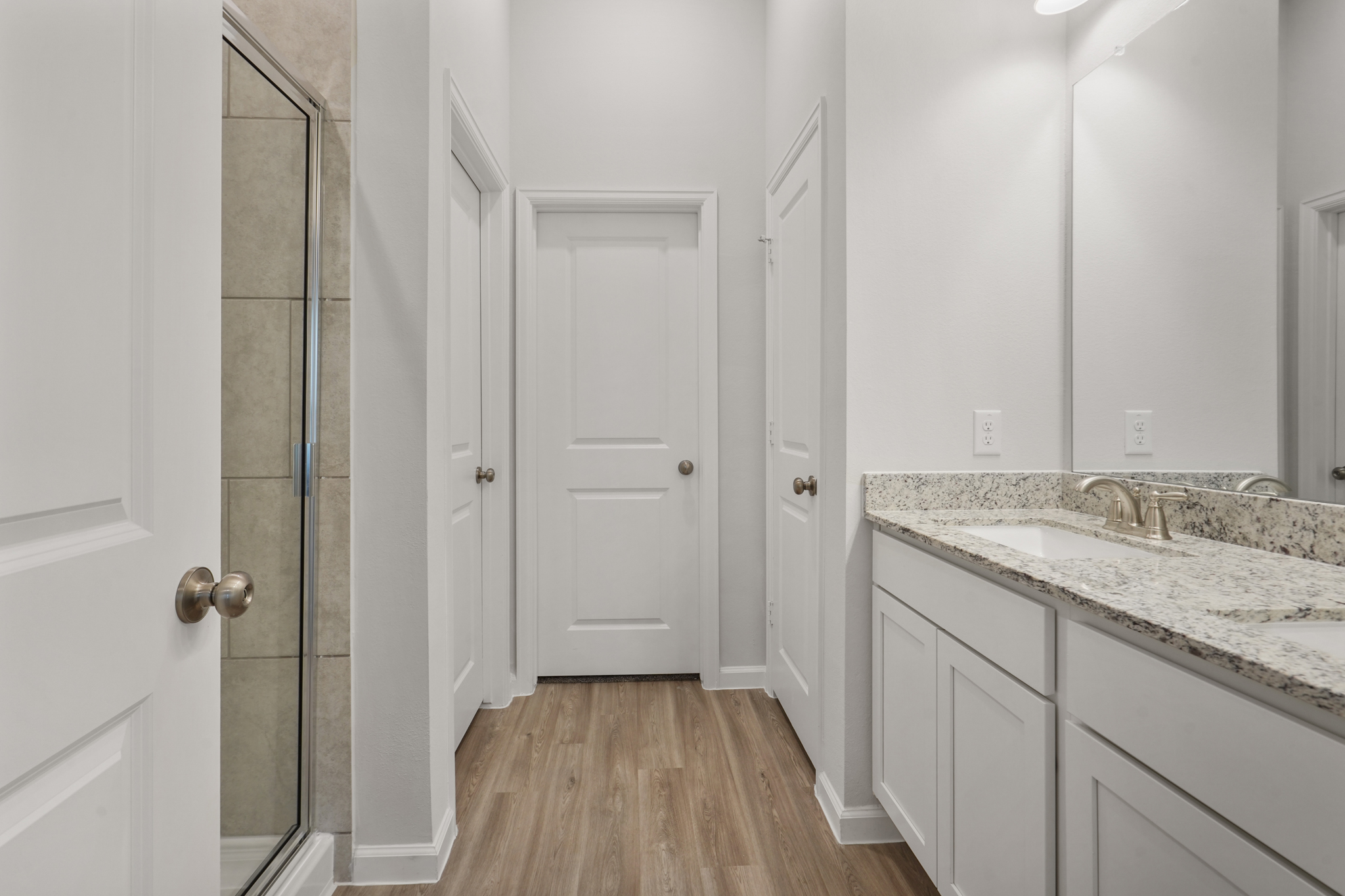 A bathroom with white cabinets.