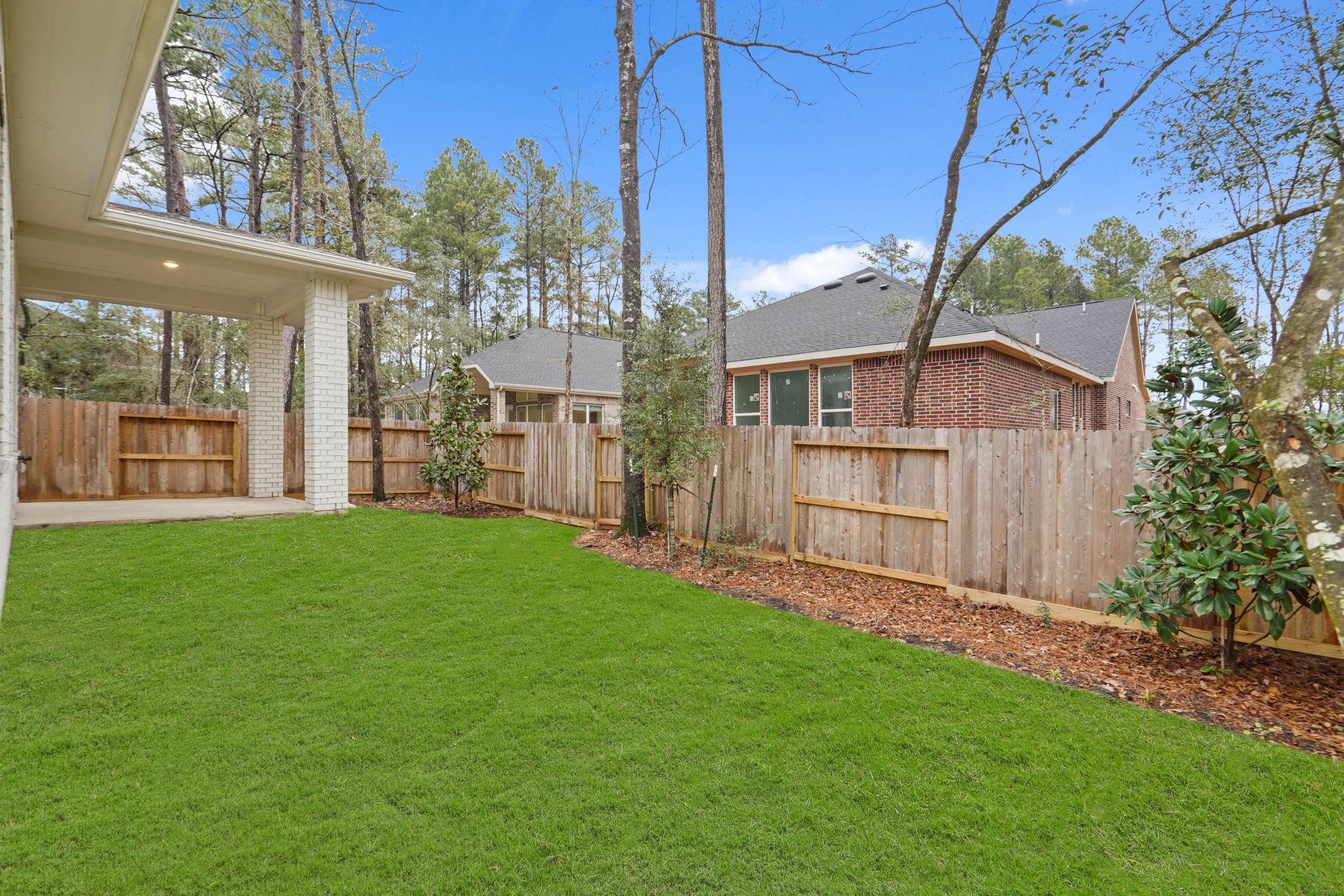 A backyard with a fence and trees.